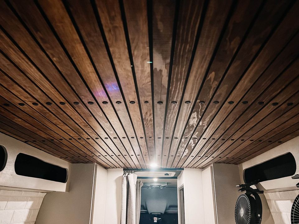 Cozy RV rental interior featuring a stylish wooden slat ceiling, storage, & fans. Perfect for a van conversion.. Mercedes-Benz Sprinter 2019