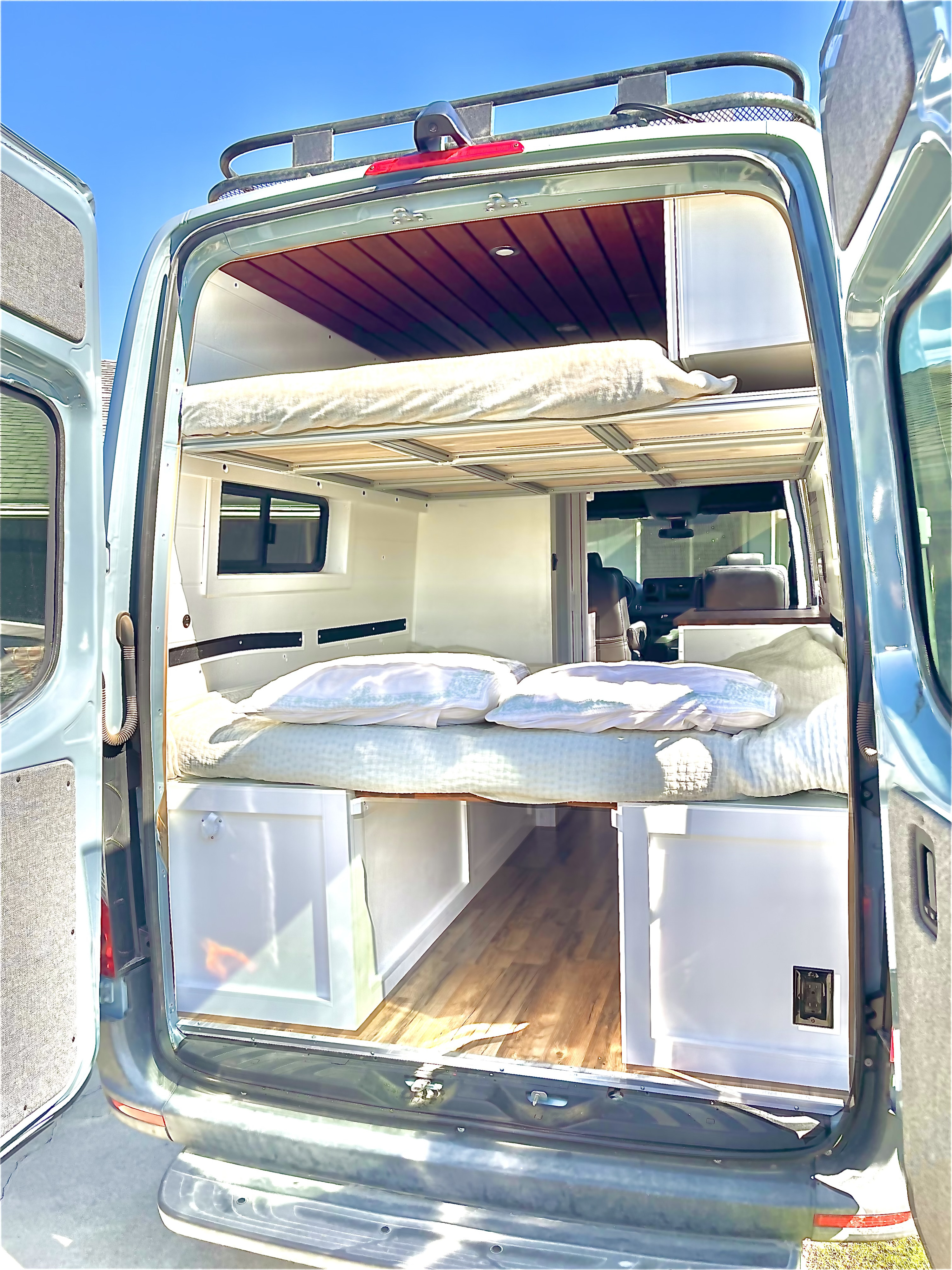 This RV rental offers a cleverly designed camper van interior, featuring a main bed, upper bunk, and built-in storage.. Mercedes Sprinter 2019