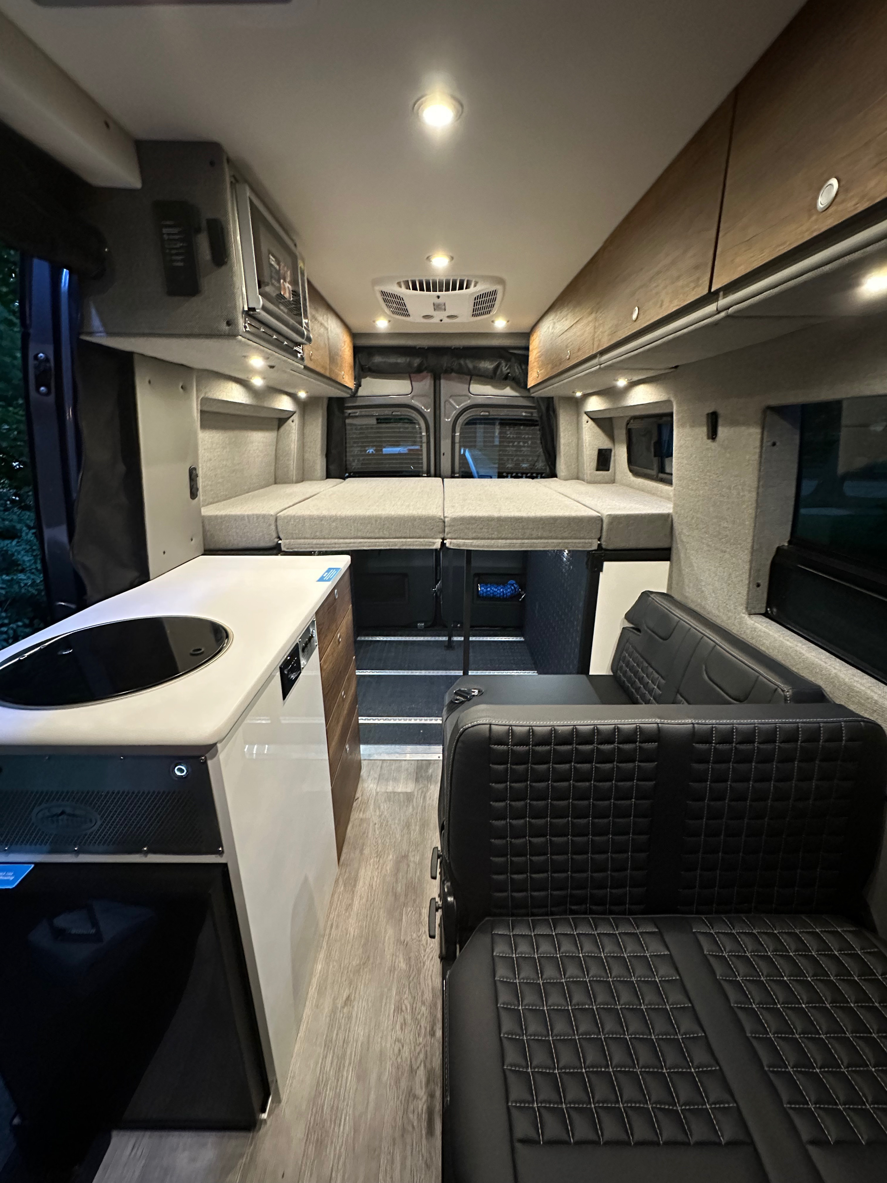 Inside this premium RV rental: a cozy, convertible bed, sleek kitchen, and plush seating for your adventures.. Storyteller Overland Storyteller Overland Class B 2022
