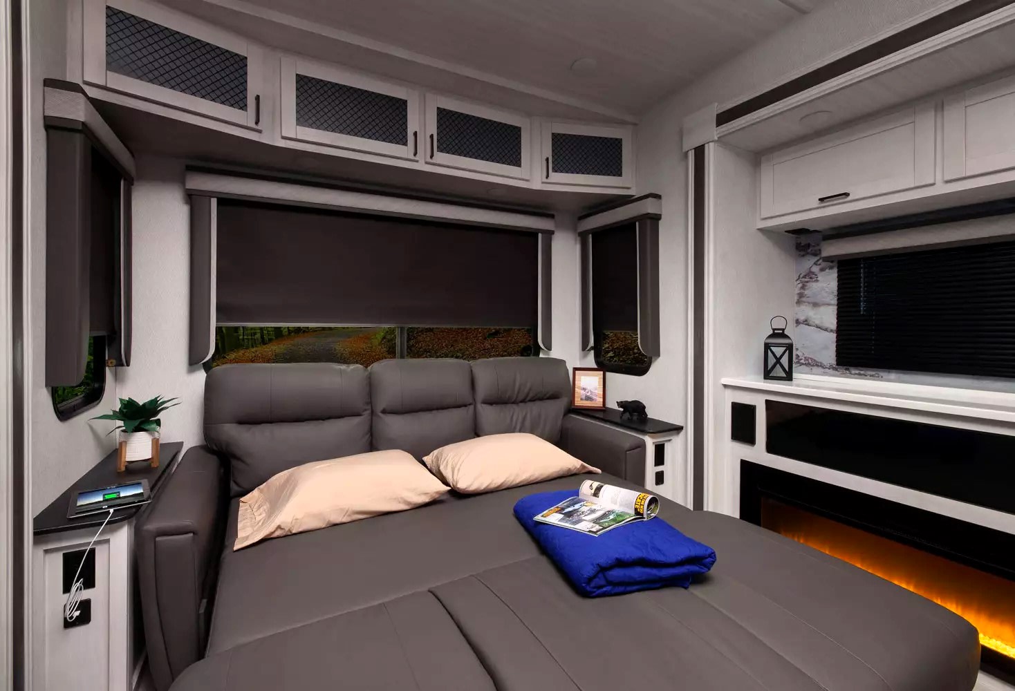 Cozy RV rental interior with convertible sofa bed, built-in fireplace, and modern amenities for comfortable travel.. East to West Ahara 2022