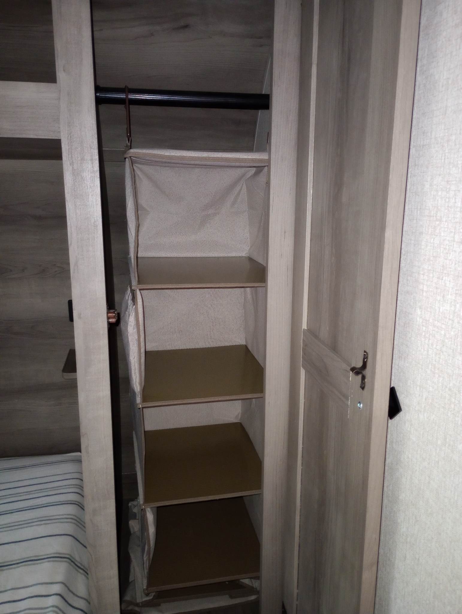 RV rental storage: Open closet featuring a multi-tiered fabric hanging organizer with shelves, ideal for compact storage.. KZ Sportsmen SE 312BHKSE (Delivery Only) 2021