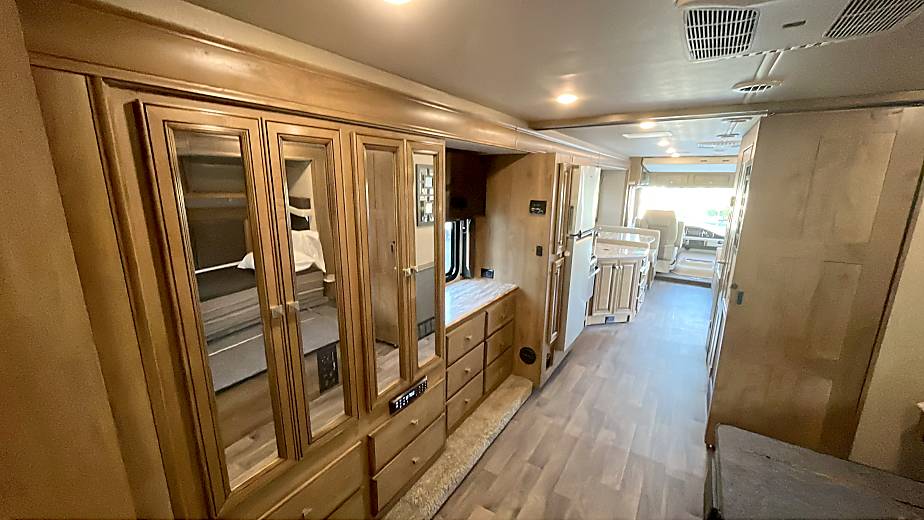 Spacious RV rental interior, showing bedroom reflection in mirrored cabinets, kitchen, and ample storage areas.. Flair-Fleetwood Flair-Fleetwood Motorhome 2020