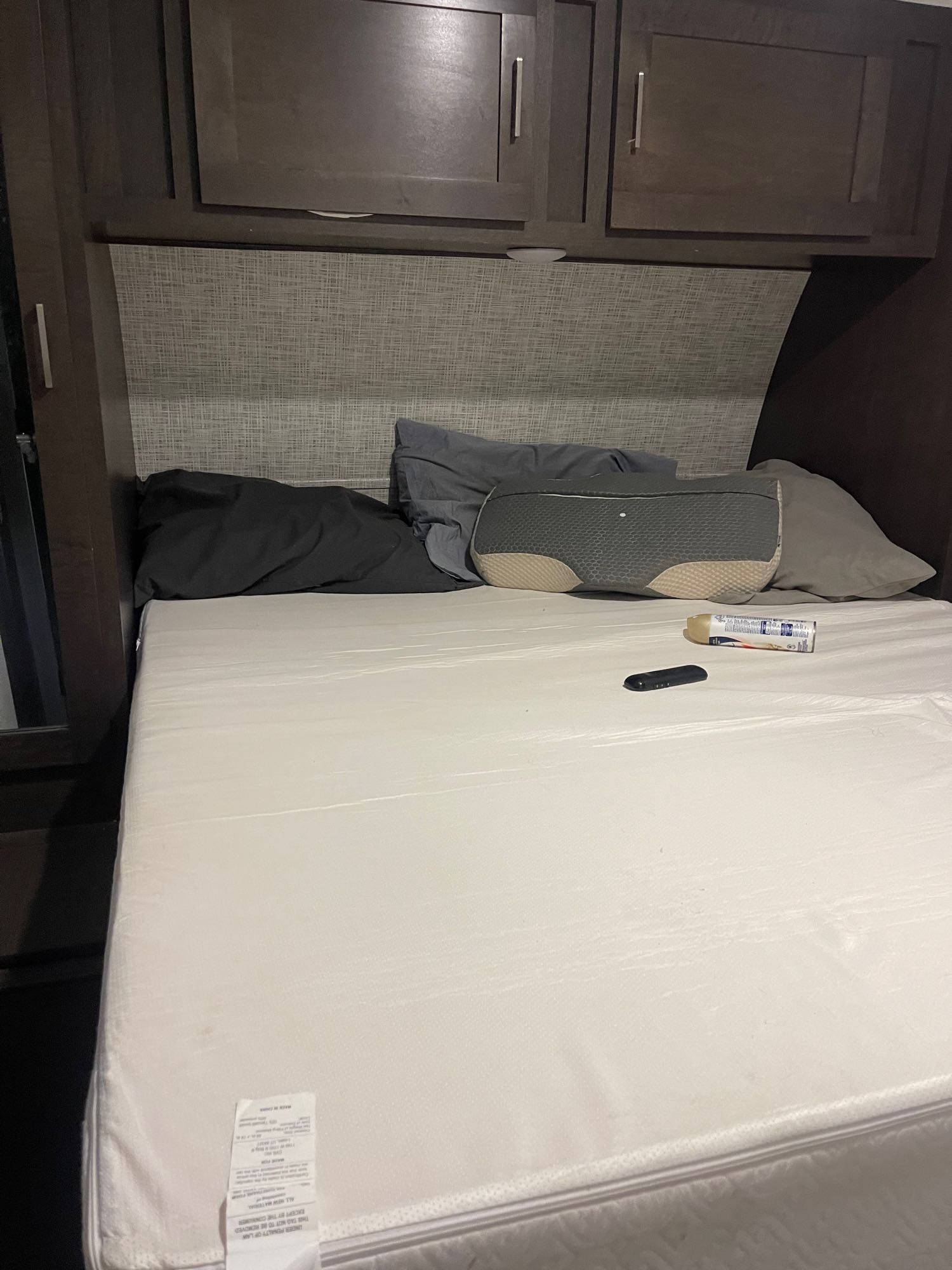 Interior of an RV rental: a neatly made bed with a new mattress, pillows, and upper cabinets, ready for rest.. Forest River Salem 2019