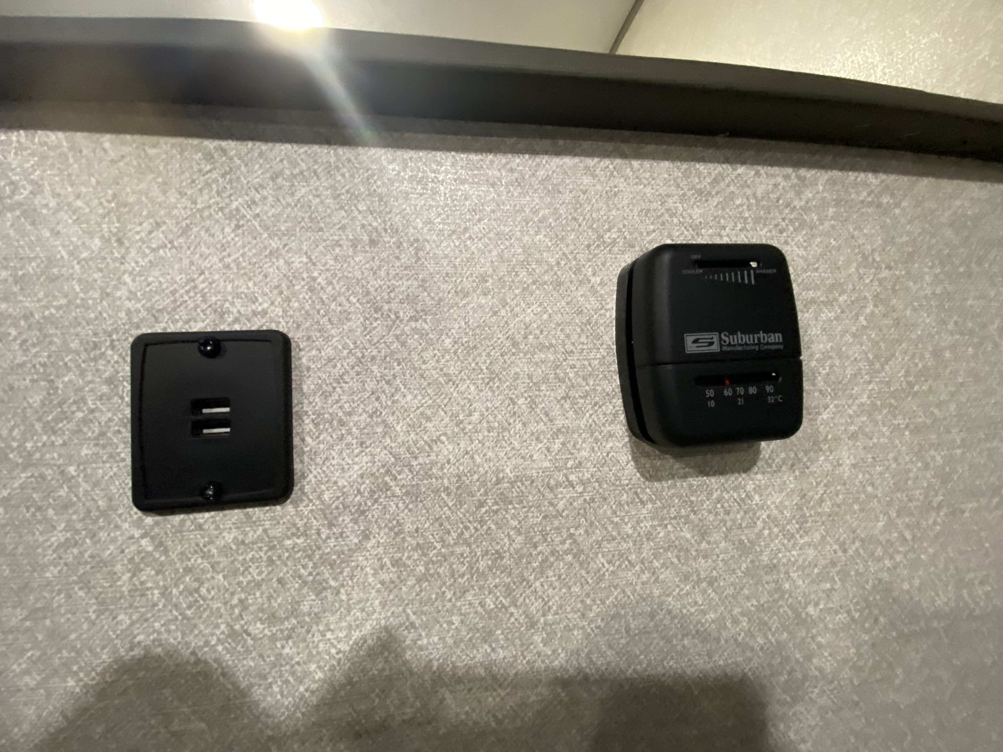 RV rental interior featuring a Suburban thermostat for climate control and a USB charger on a textured wall.. Forest River Salem FSX 2020