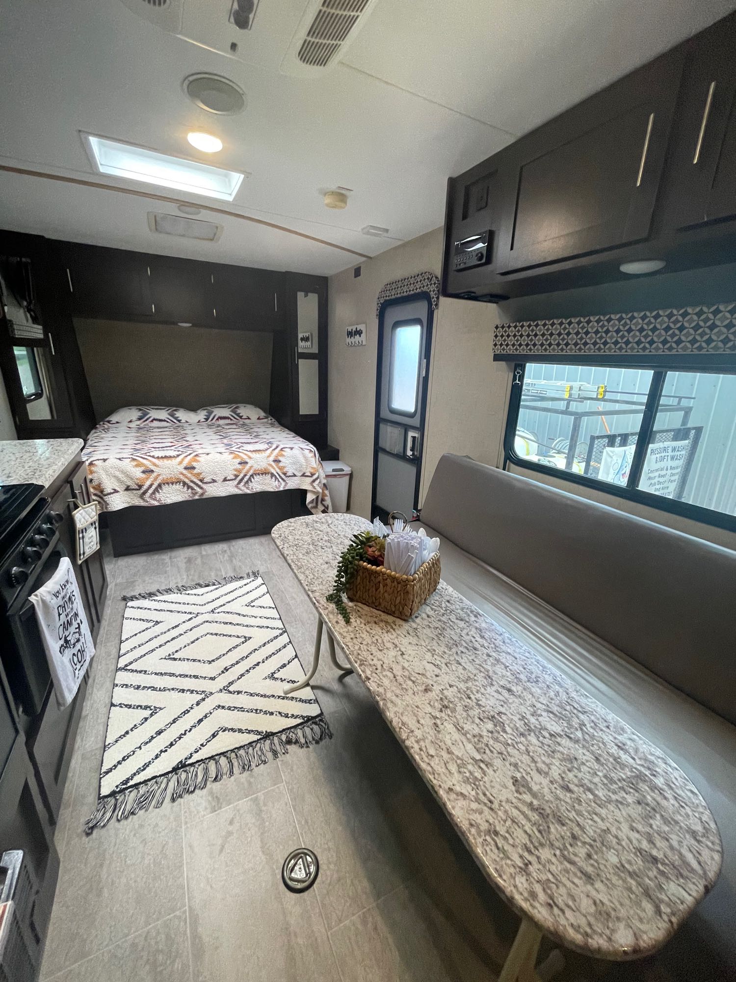 Cozy RV rental interior with a bed, kitchen, and dinette, perfect for travel adventures and comfortable living.. K-Z Manufacturing Sportster 2018