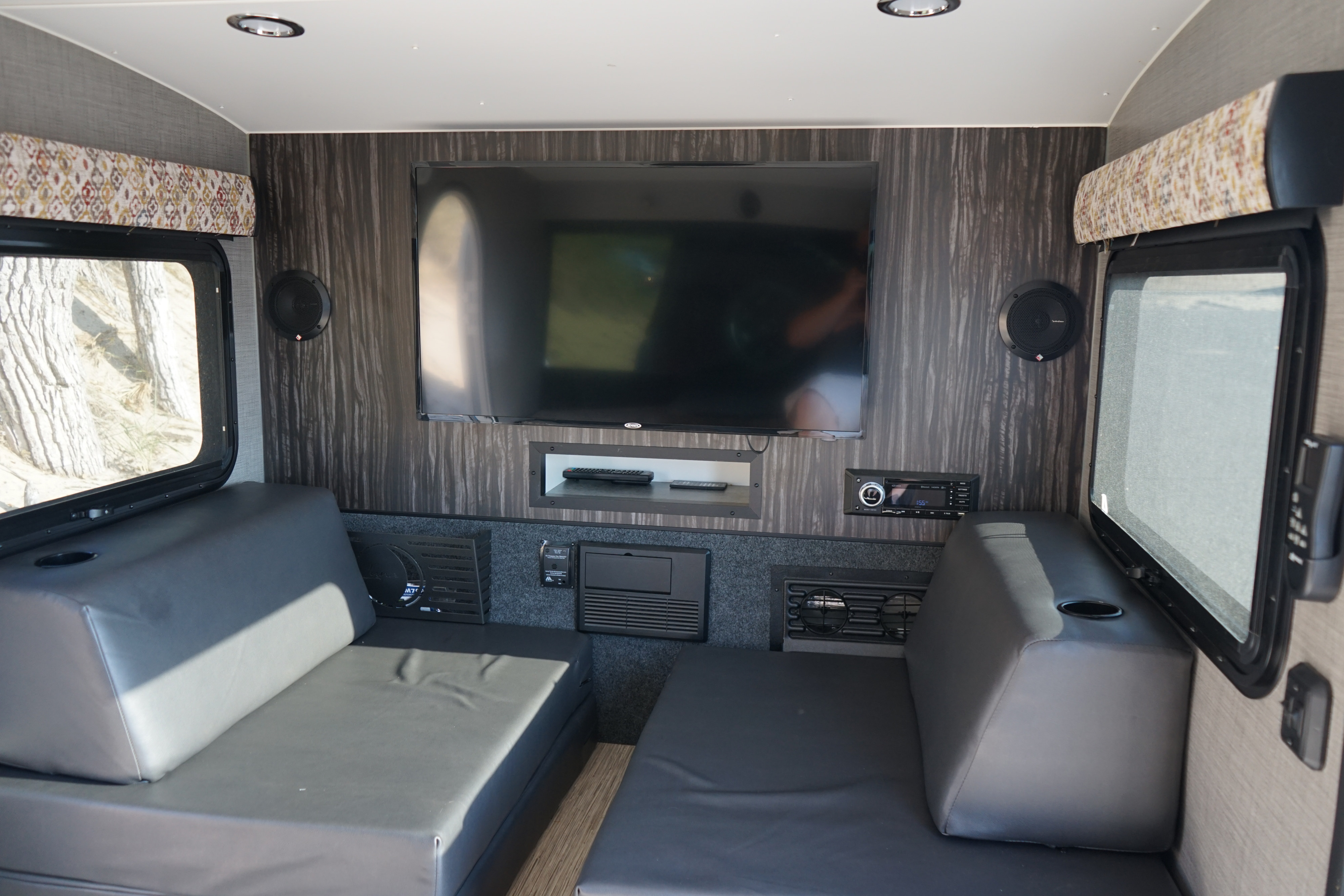 Experience comfort in this RV rental's living area featuring dual benches, a large TV, and integrated audio system.. intech Luna 2018