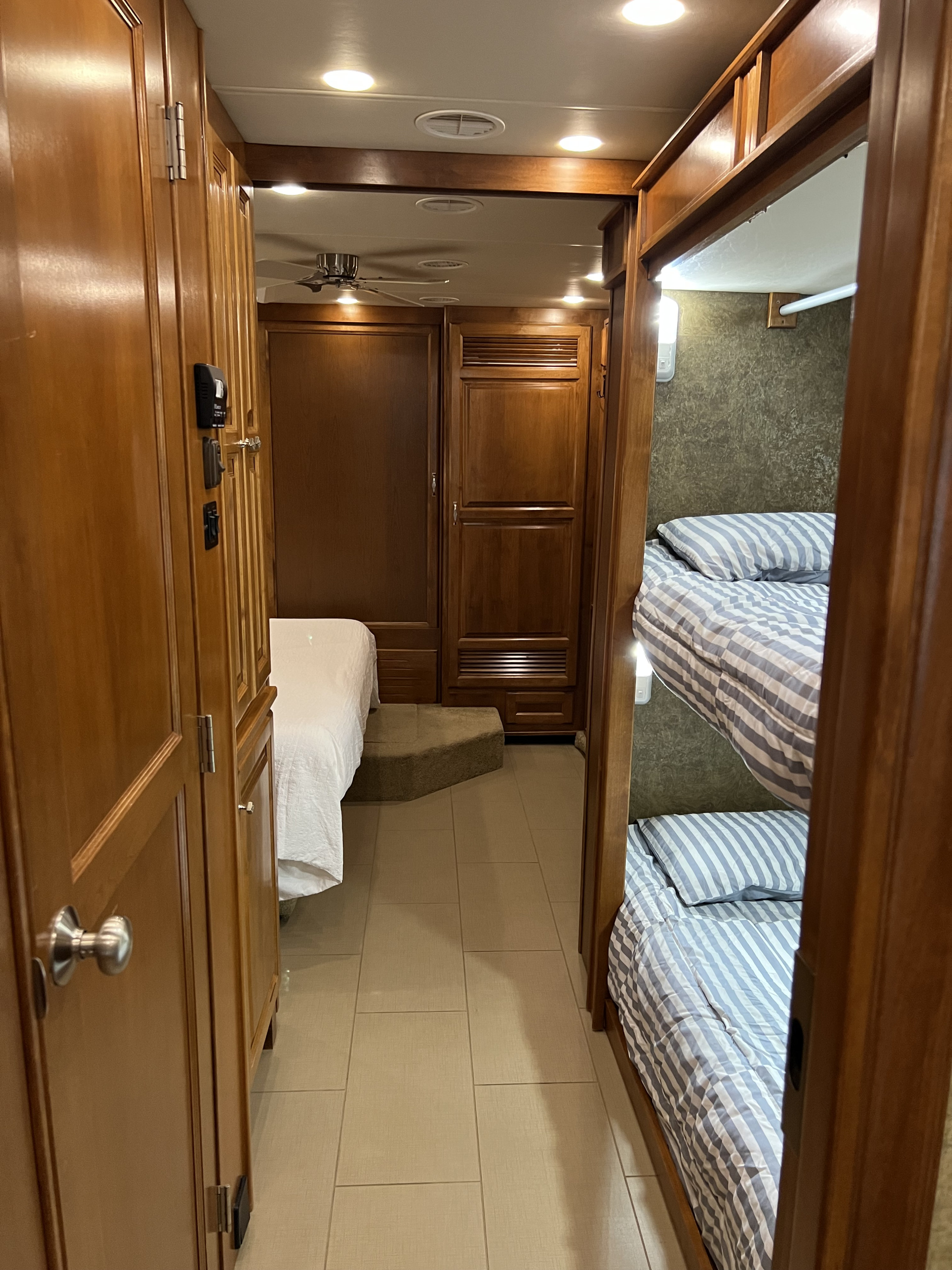 Spacious RV rental interior with a cozy master bedroom, bunk beds, and rich wood finishes for comfortable travel.. Phaeton Phaeton Motorhome 2014