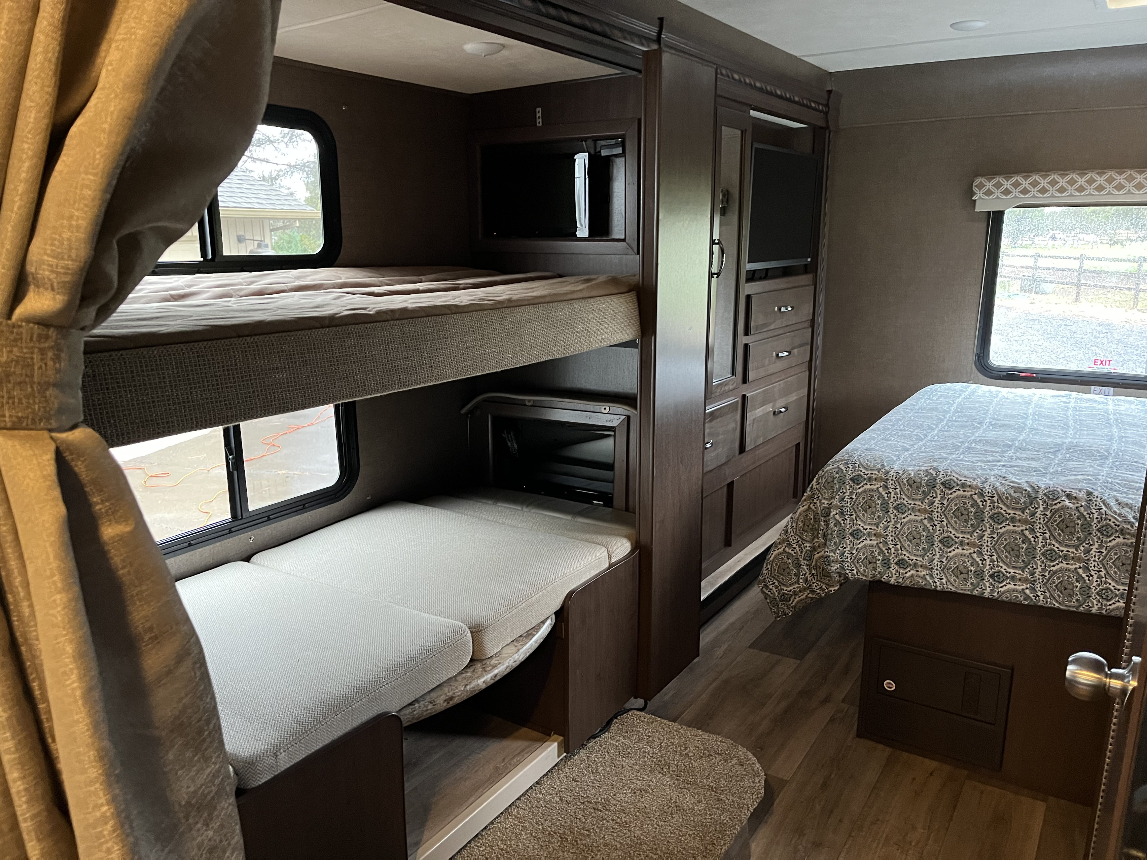 RV rental interior: bunk beds with a lower seating area, built-in storage, and a main bed. Ready for your next travel adventure!. Thor Freedom Elite 2018