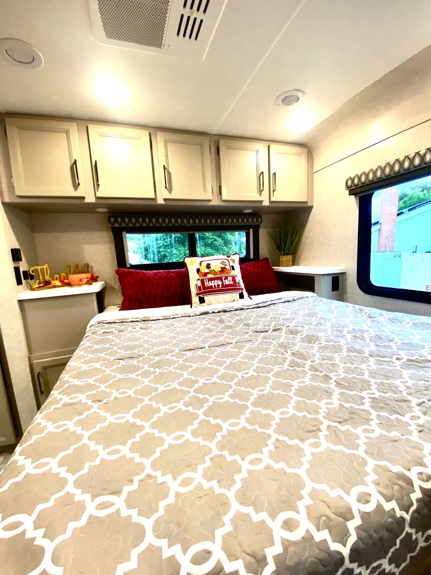 Spacious RV rental bedroom with festive fall decor, comfy bed, and ample storage. Your cozy travel home awaits!. Thor Quantum 2023