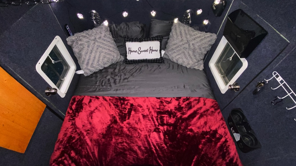 Experience a cozy RV rental with this bedroom featuring a plush bed, "Home Sweet Home" pillow, and diamond windows.. Custom One Of A Kind Escape Pod 2019