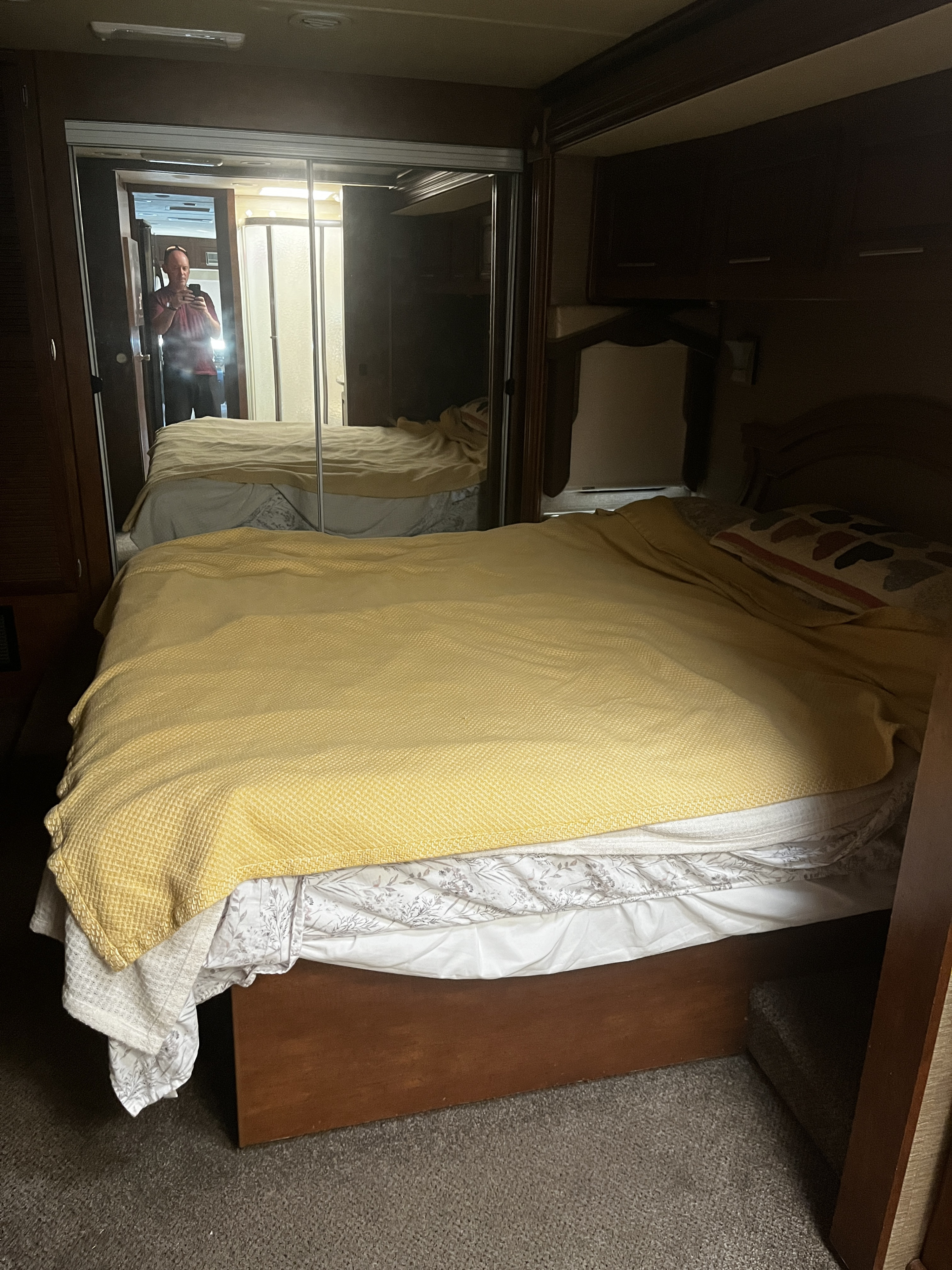 RV rental bedroom with a cozy bed and large mirrored closet reflecting the photographer, phone, and shower.. Forest River Coachmen Pathfinder 2014