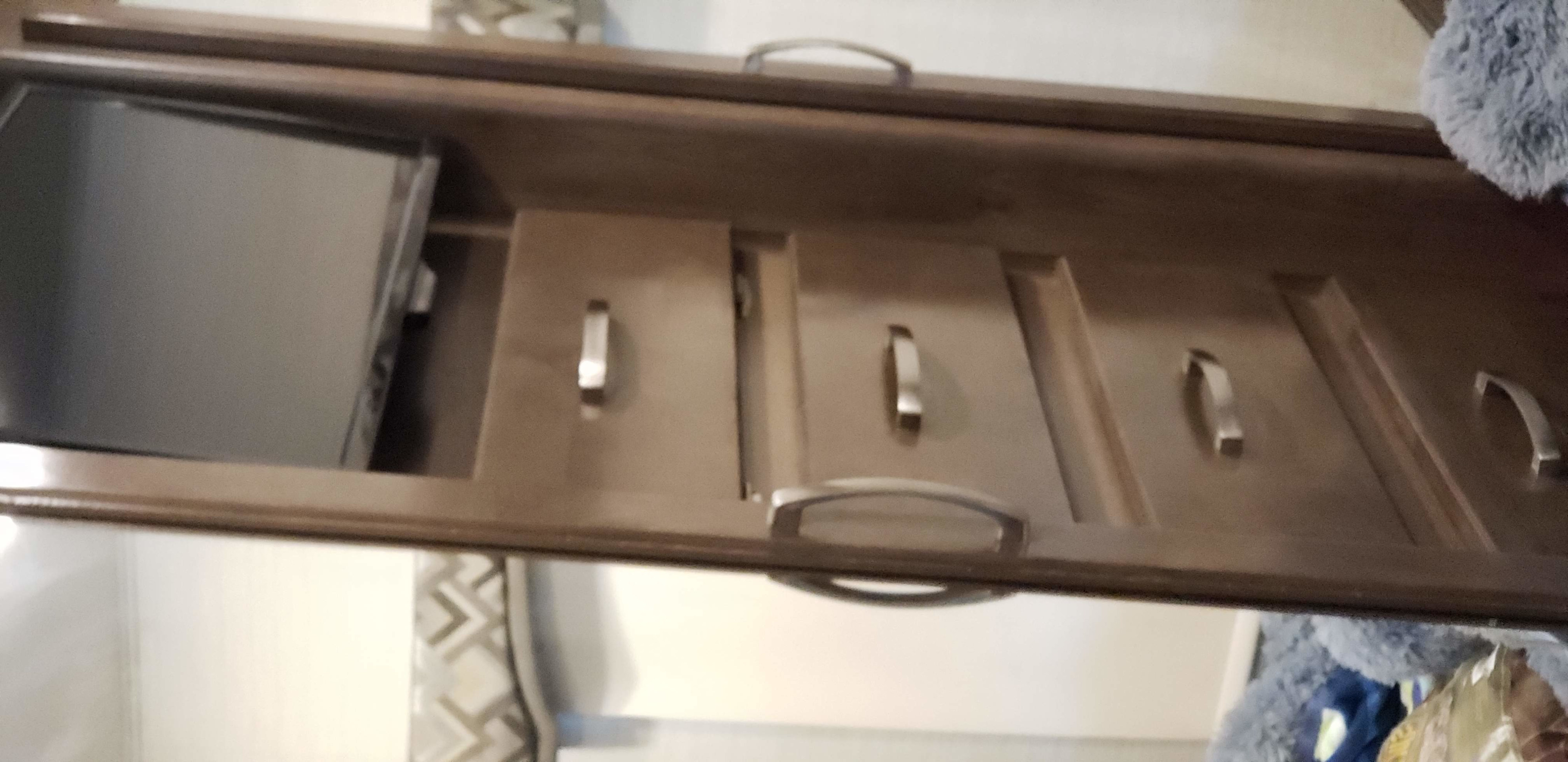 This RV rental's interior features a mounted TV above three wood drawers, providing compact storage in the cabin.. Jayco Alante 2019