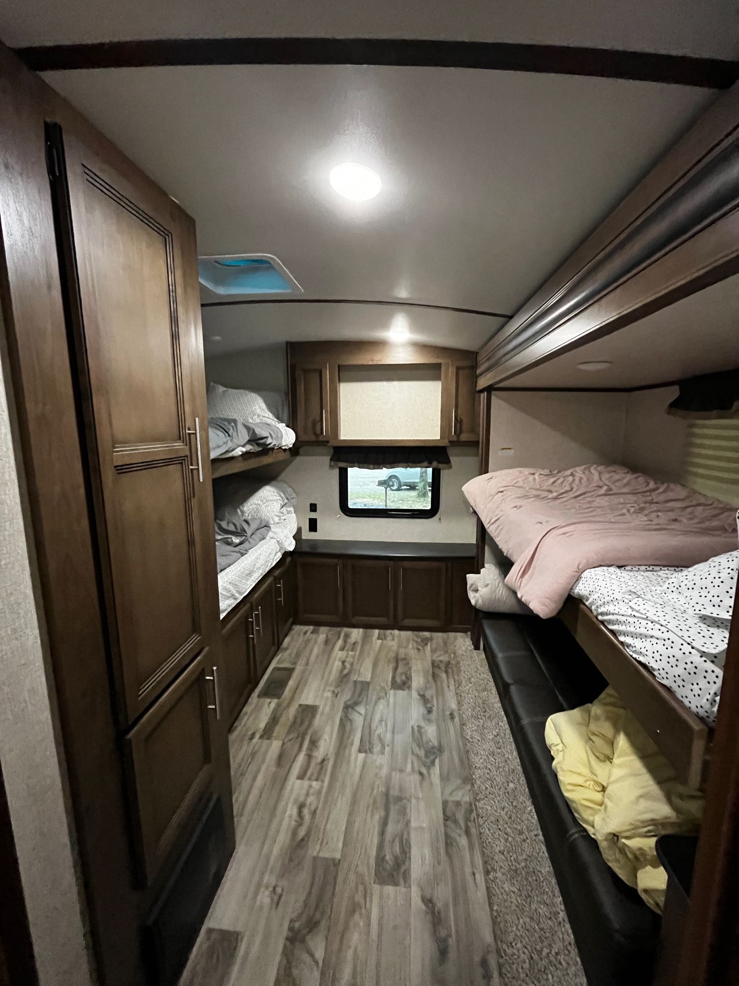 Roomy RV rental bunkhouse features multiple bunk beds, wood-look floors, and ample storage cabinetry.. Keystone RV Cougar 2020
