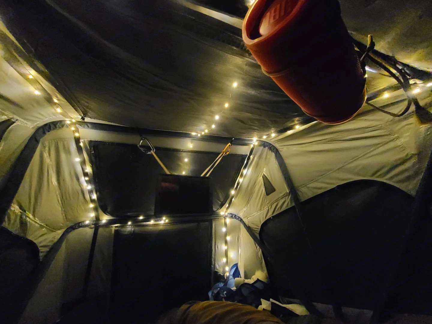 Cozy RV rental interior at night, illuminated by fairy lights, with a JBL speaker. Perfect for camping comfort.. Toyota RAV4 2003