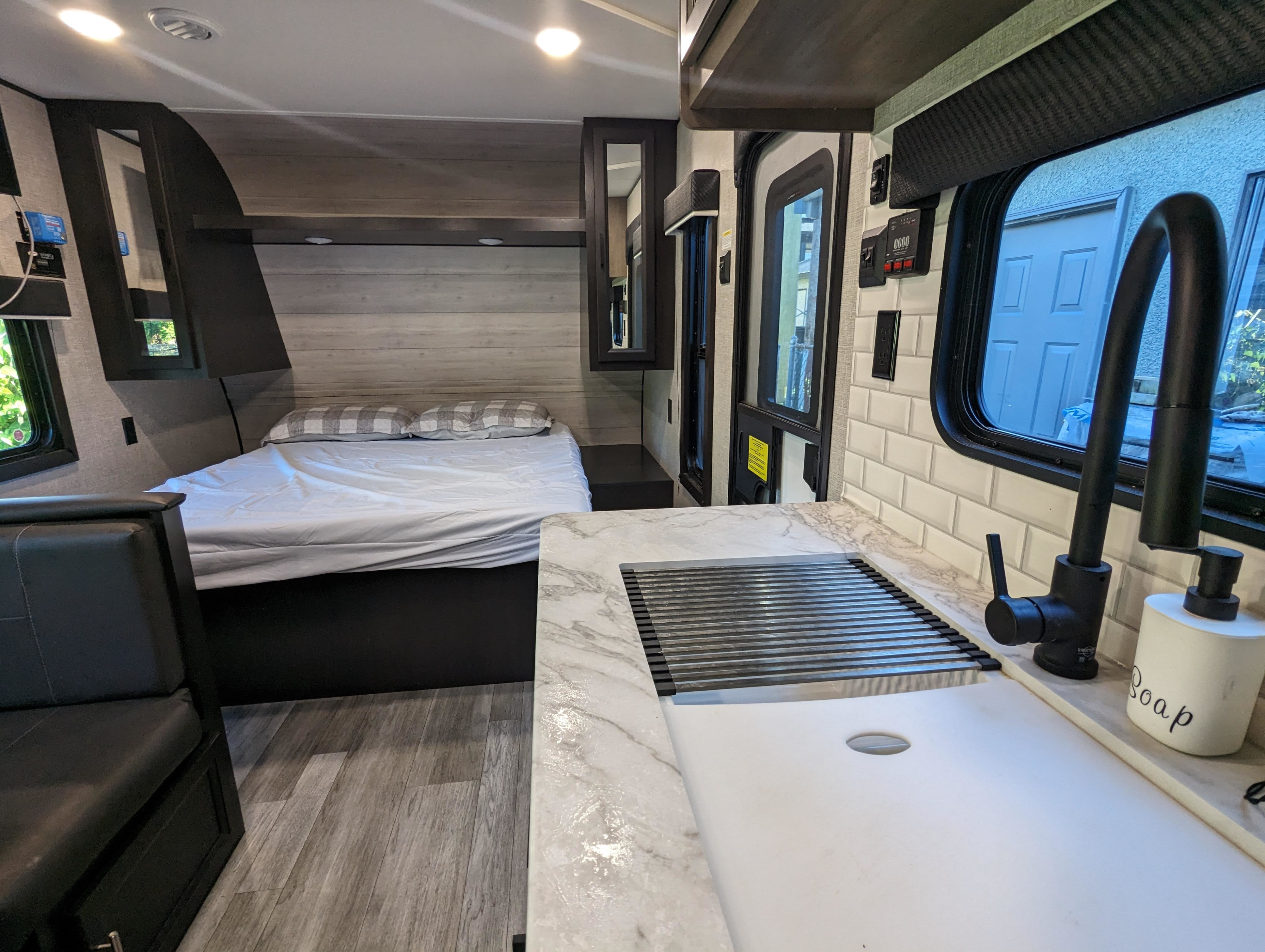 Inside this RV rental: a comfy bed, functional kitchen with marble counter & subway tile, plus a cozy seating area.. Jayco Jay Flight SLX Rocky Mountain Edition 2022