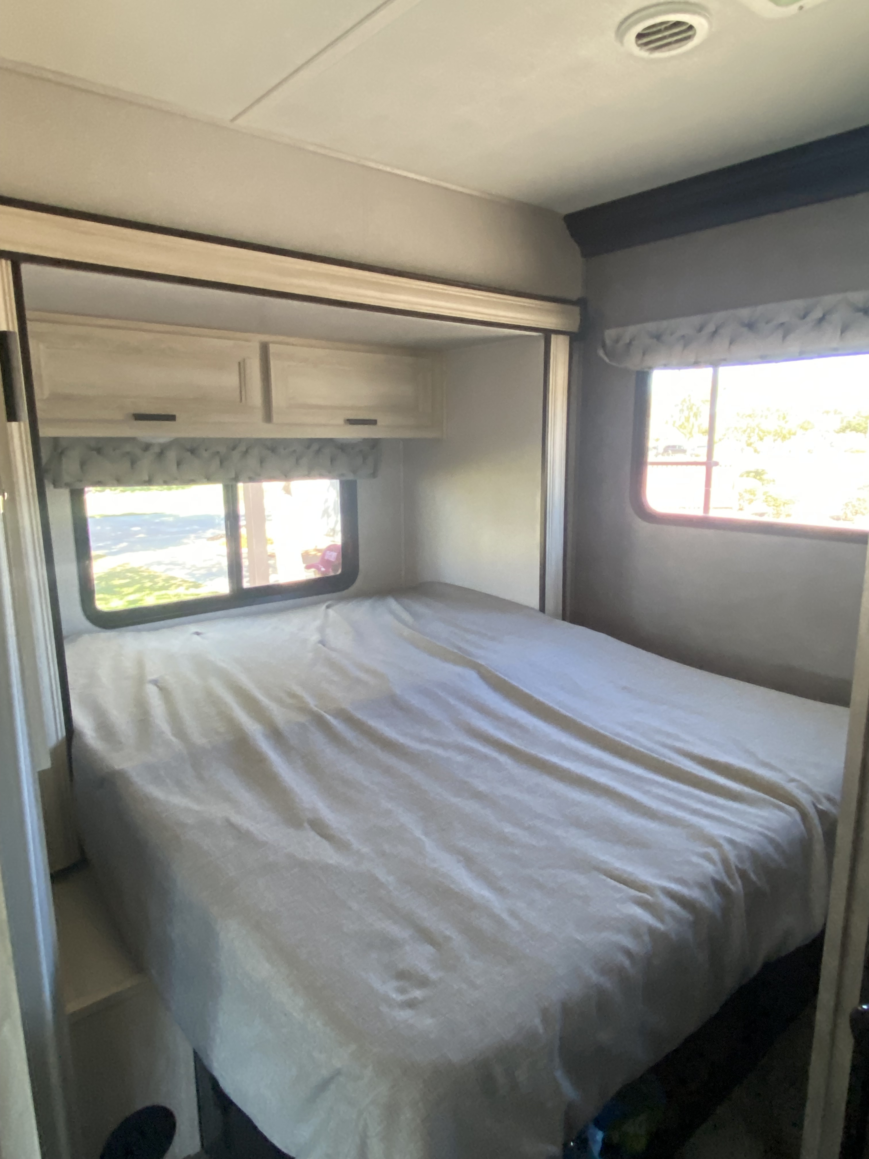 Explore this tidy rv rental bedroom: A comfy bed, overhead storage, and dual windows offer natural light.. Forester LE 2021