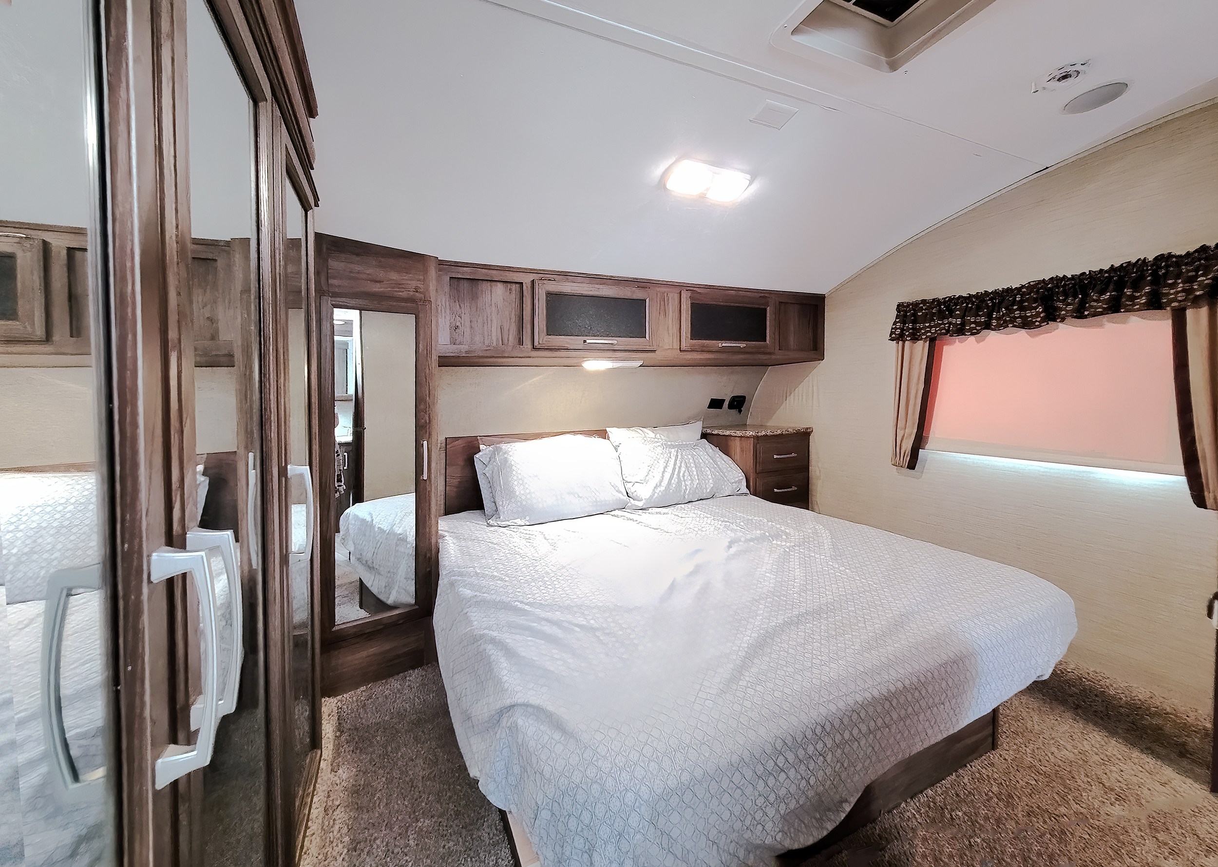 RV rental bedroom with comfortable bed, overhead storage, and mirrored closet. Perfect for your next road trip!. Keystone Cougar 2017