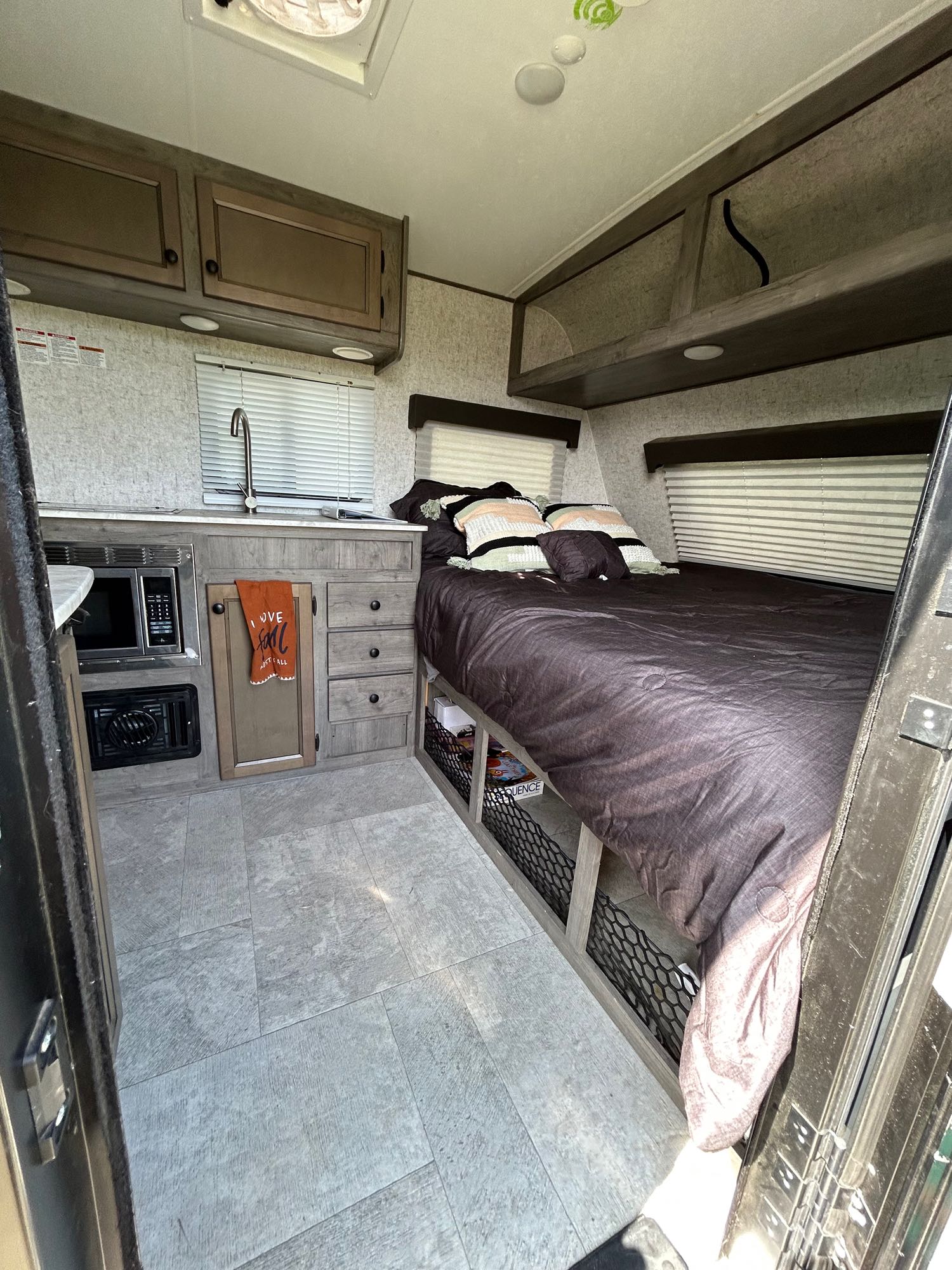 Cozy RV rental interior featuring a compact kitchen, comfortable bed, & smart storage. Perfect for adventurers.. Apex Tera 15T 2020