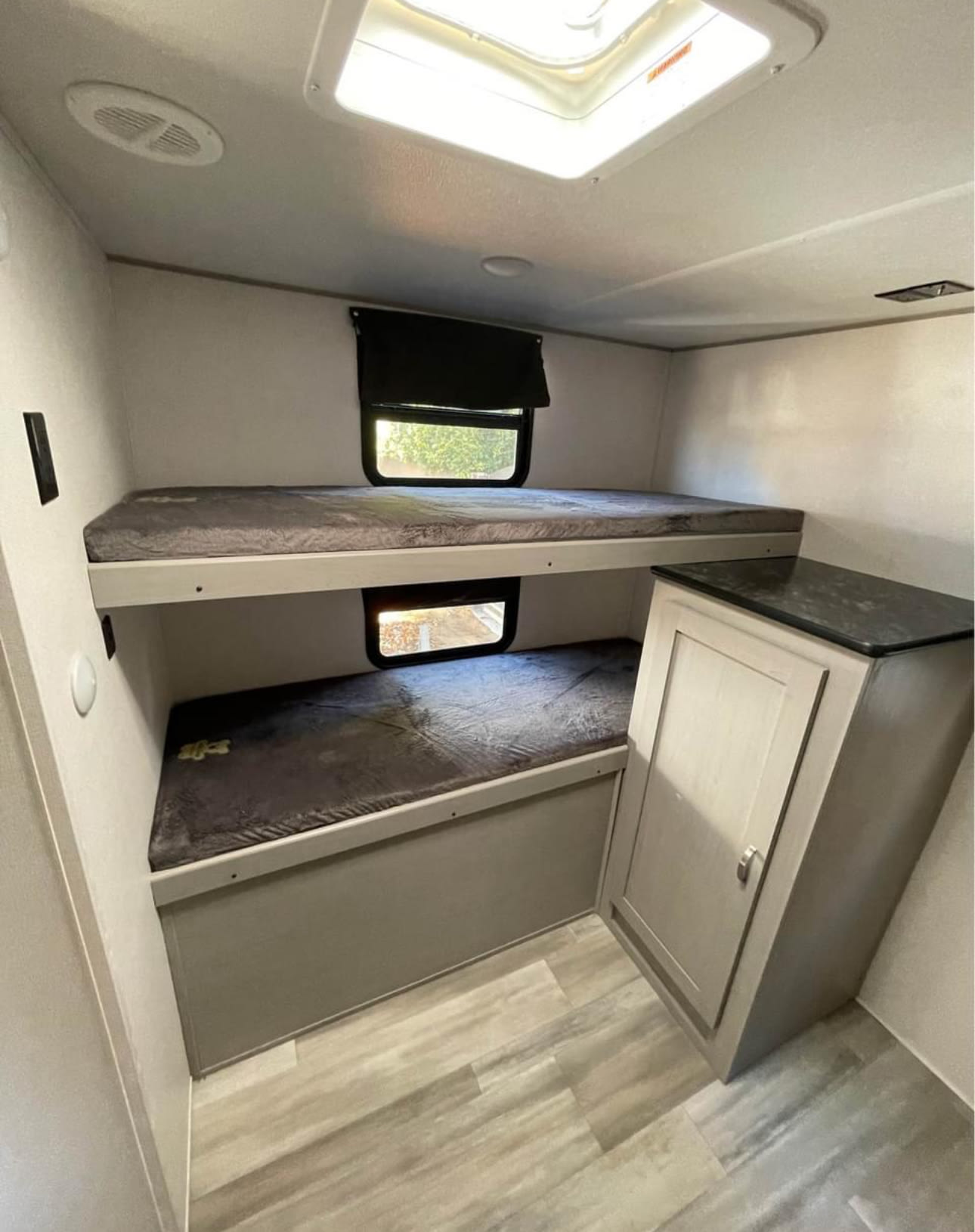 RV rental bunk beds offer comfortable sleeping for two, with windows and a convenient storage cabinet.. Forest River Tracer 2021