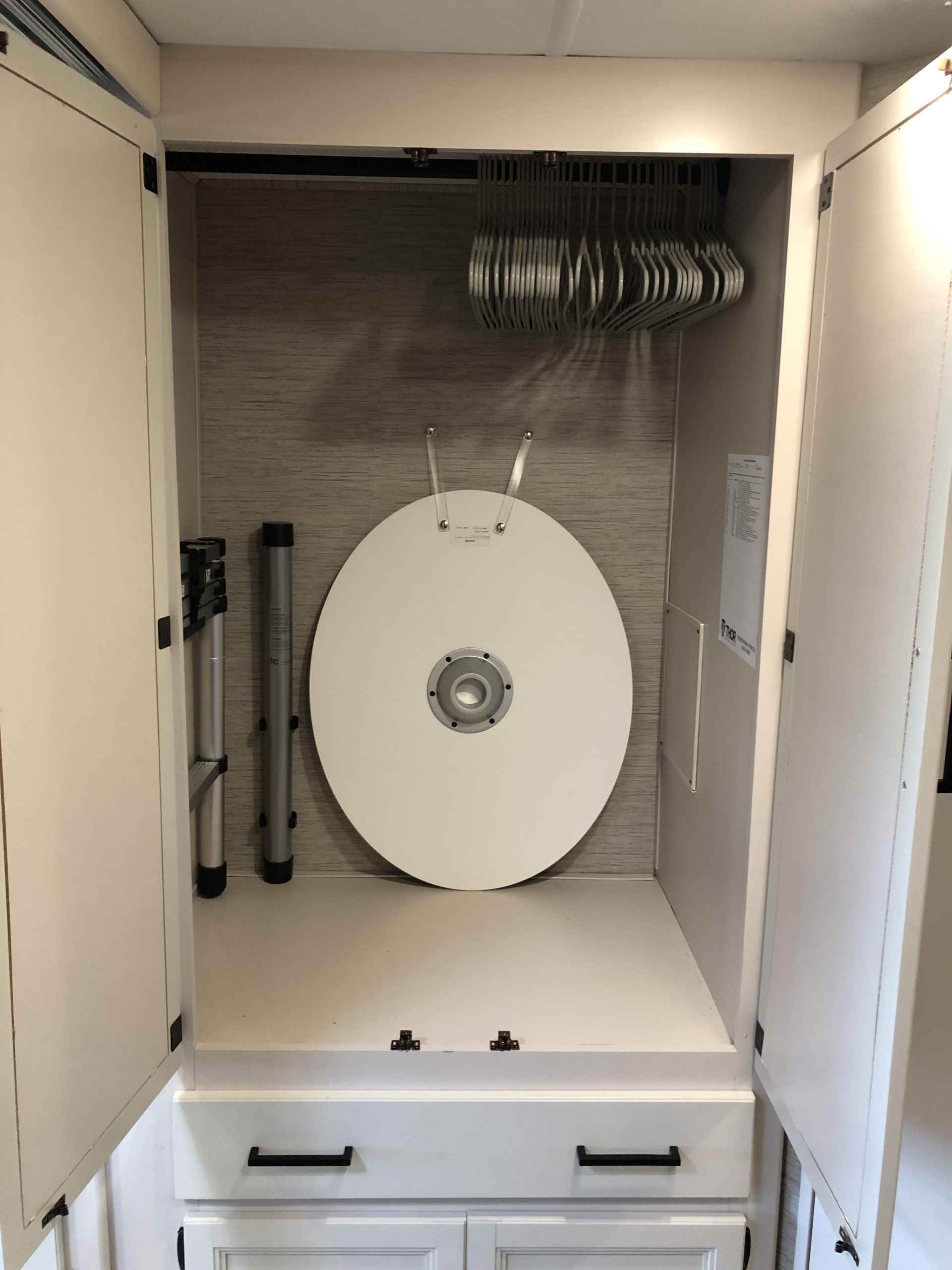 RV rental interior: A neatly organized closet featuring a portable white table, hangers, and support poles.. Thor ACE 2022