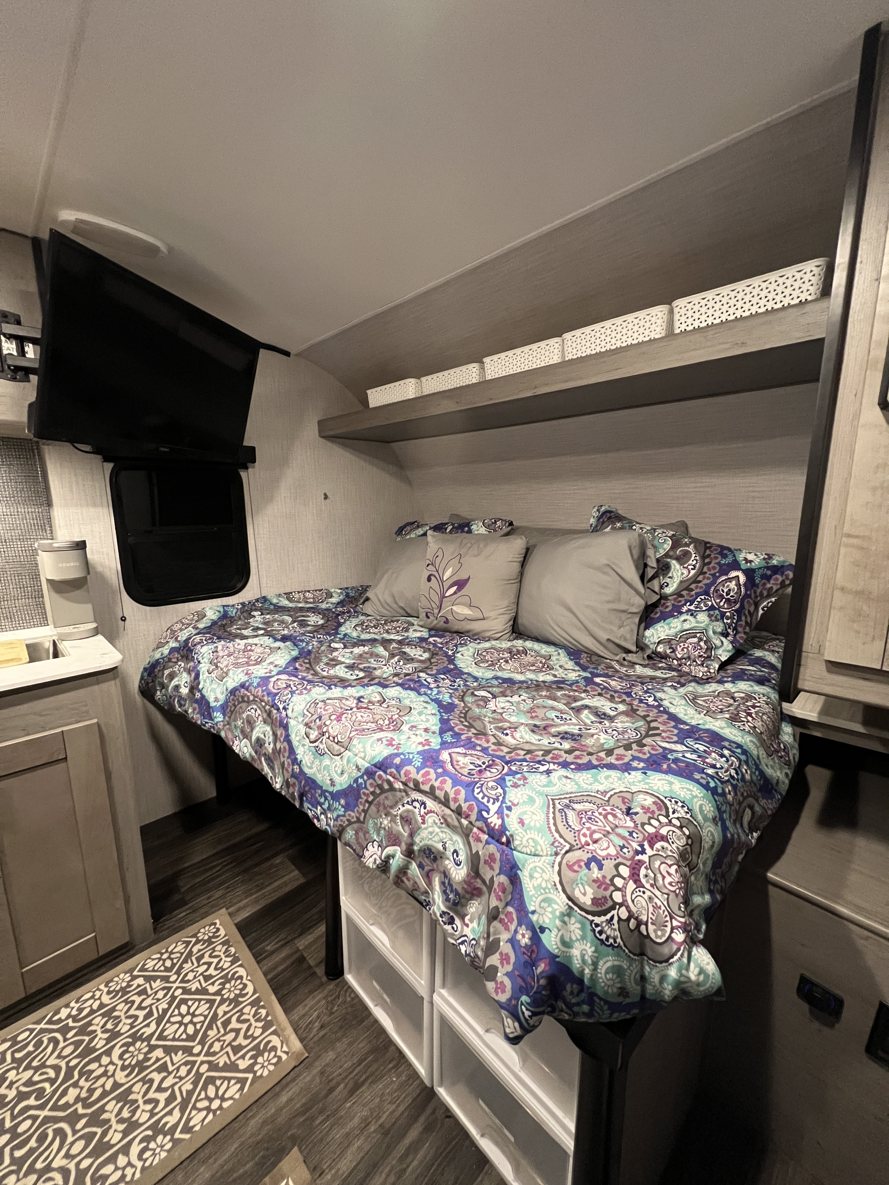 RV rental bedroom with a full bed, TV, Keurig, and clever storage solutions, providing comfort on the road.. Heartland RVs Mallard 2021