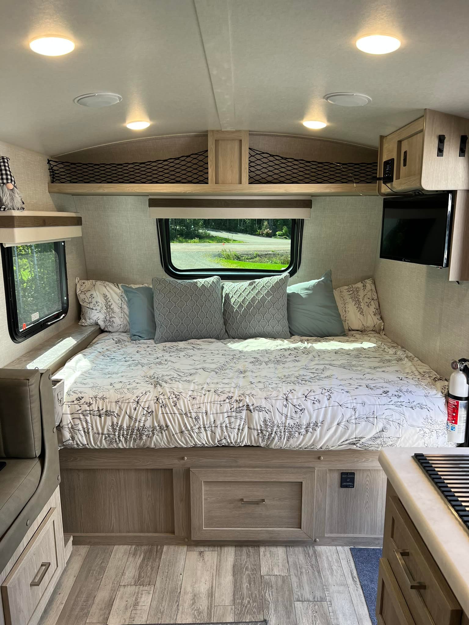 Cozy RV rental interior with a comfortable bed, windows, TV, and smart storage.. Forest River Rockwood Geo Pro 2022