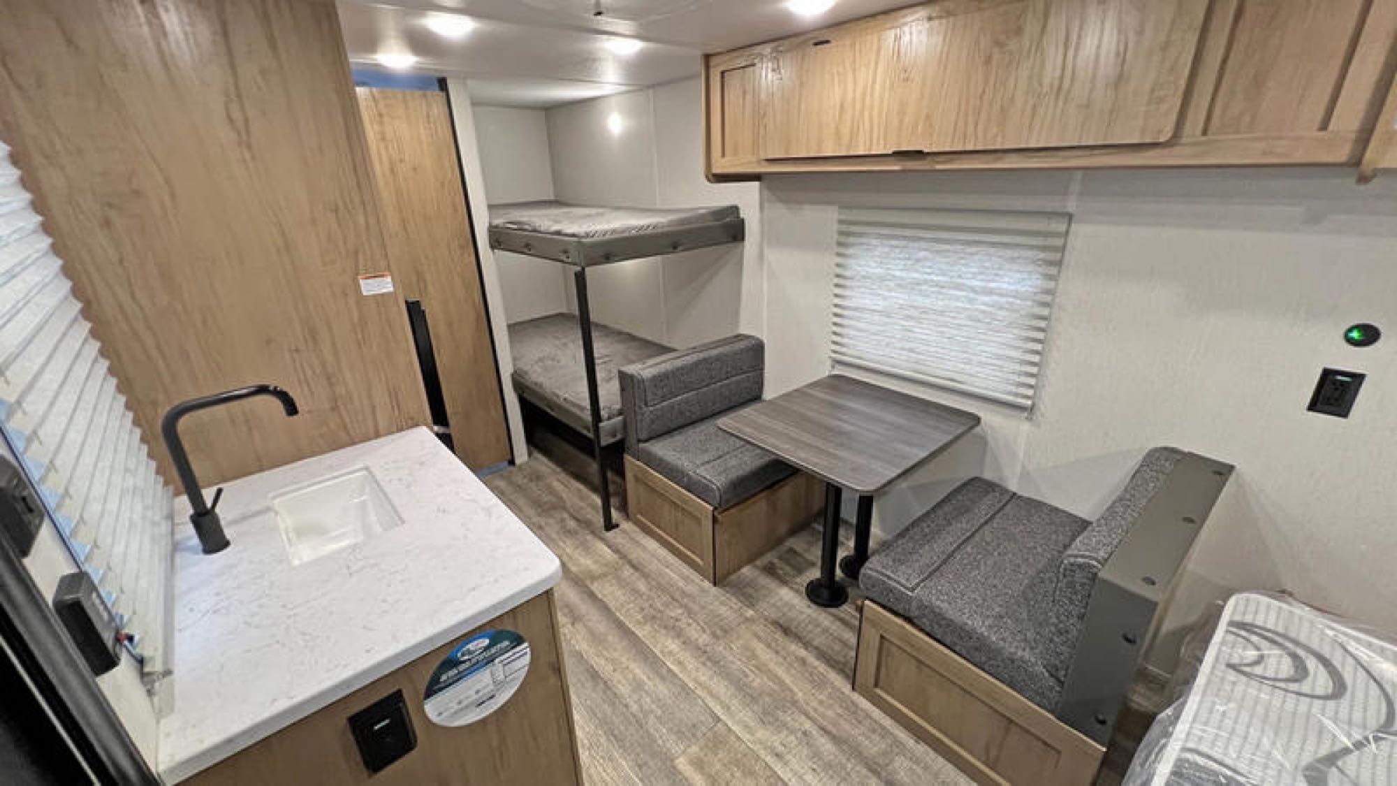 RV rental interior with bunks, a dinette, and a kitchen sink area. Ideal for family trips.. Forest River Cherokee Wolf Den 16EV 2024