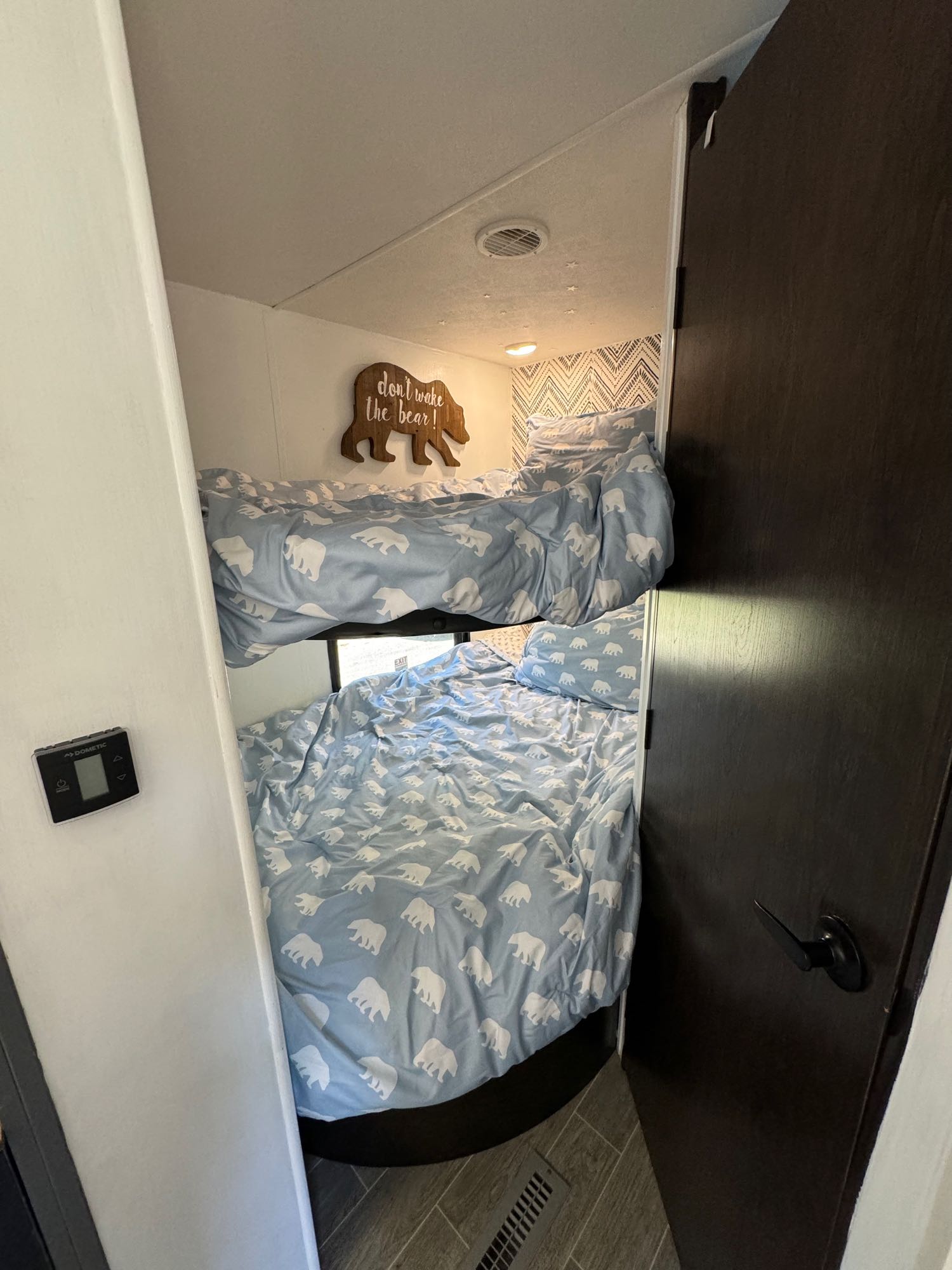 Cozy RV rental bunk beds with light blue polar bear bedding, a fun "don't wake the bear!" sign, and Dometic controls.. Heartland RVs Trail Runner 2020