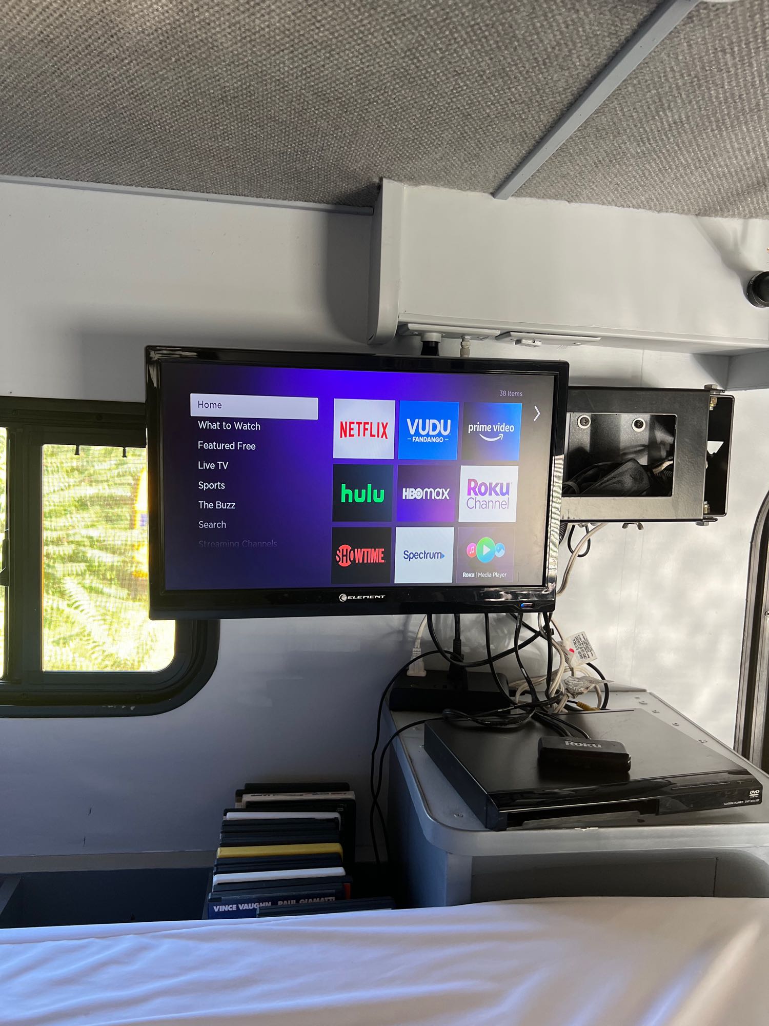 RV rental interior featuring a TV displaying Netflix, Hulu, Roku streaming apps, a DVD player, and movie collection for entertainment.. Tioga Ranger 2011