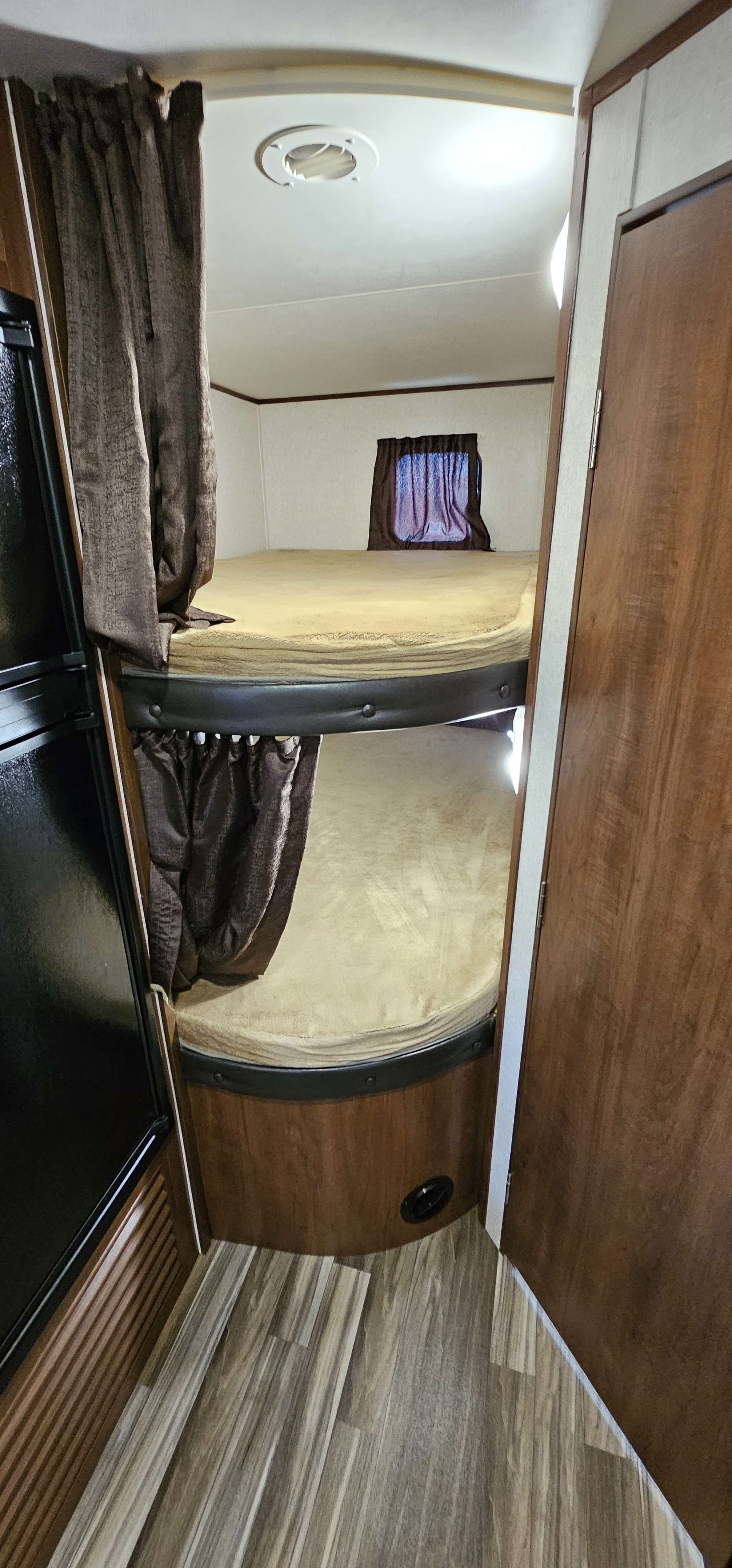 Experience comfort in this RV rental with double bunk beds, privacy curtains, and compact interior space for travelers.. Jayco Jay Flight 2017