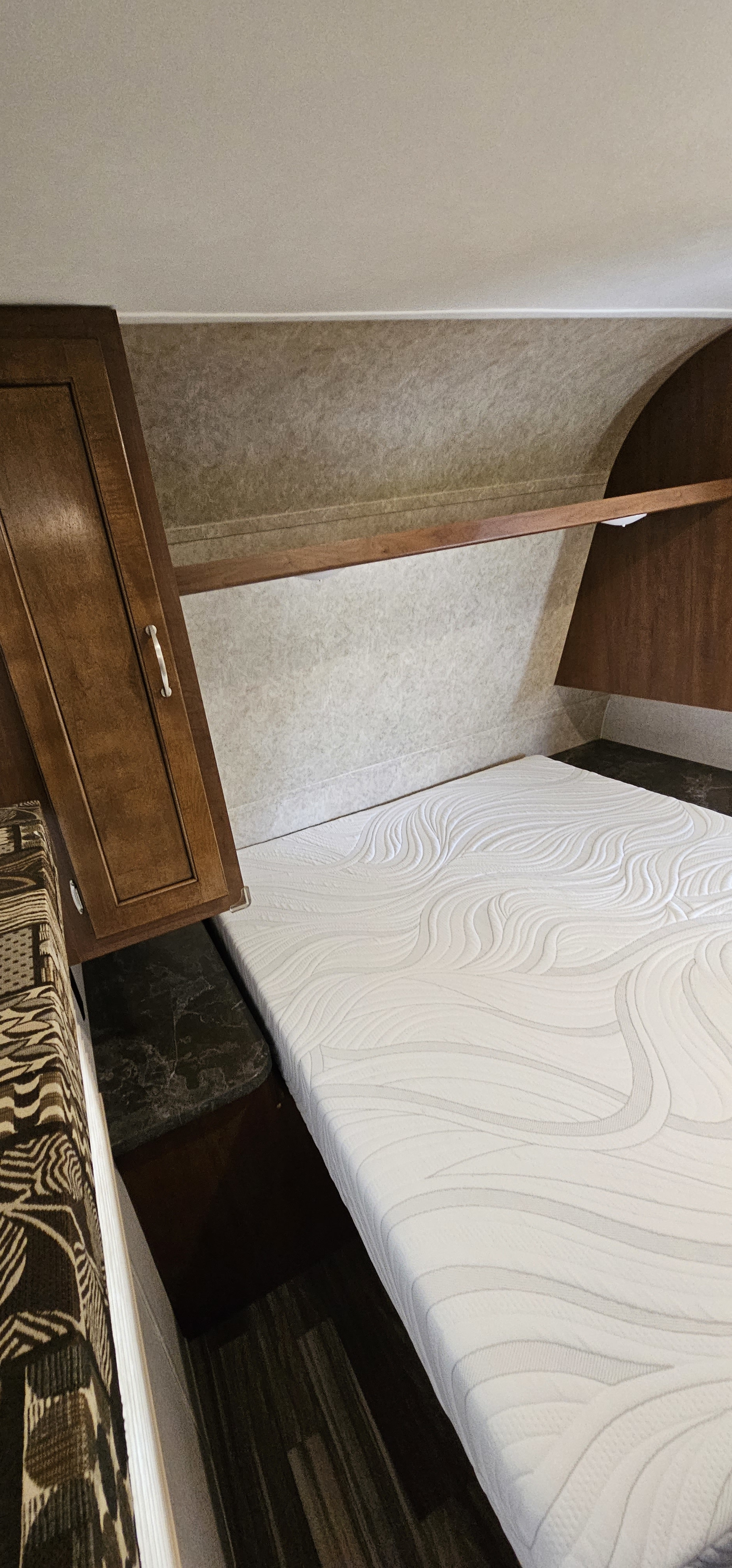 Comfortable RV rental bedroom with a fresh white mattress, wood paneling, and storage cabinets.. Jayco Jay Flight 2017
