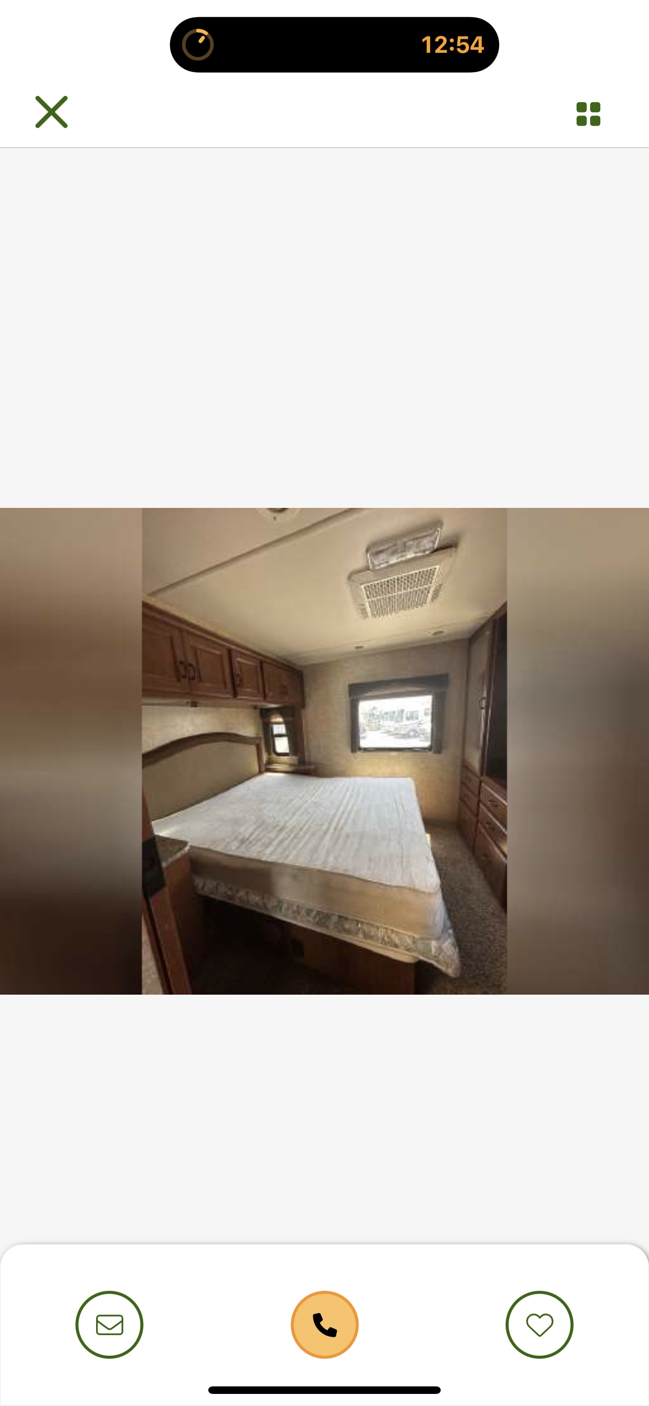 Spacious RV rental bedroom with comfortable mattress, overhead cabinets, and window. Ideal for compact travel.. Four Winds Hurricane 2011