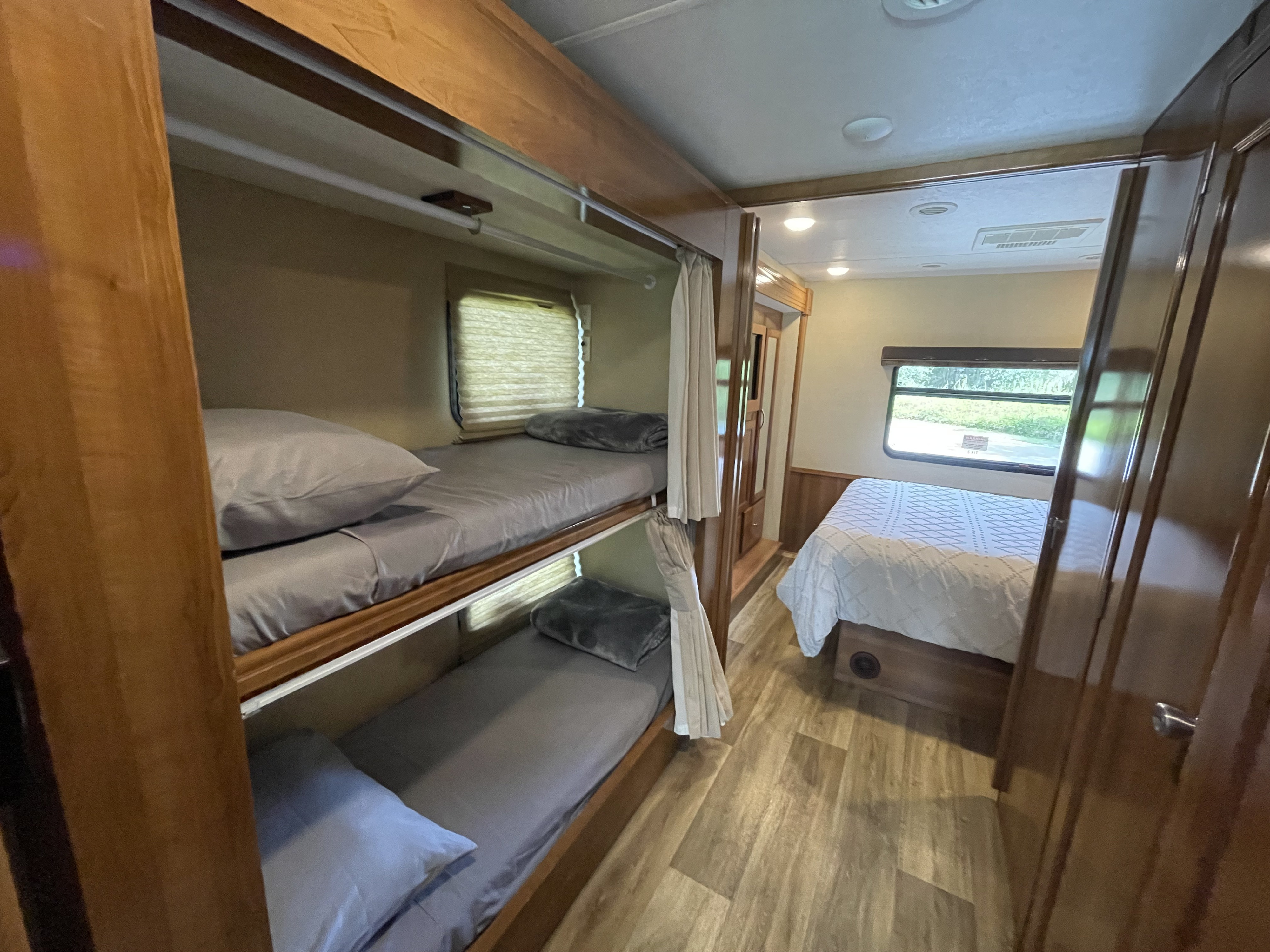 Spacious RV rental interior featuring cozy bunk beds and a main bedroom. Ideal for family trips.. Coachmen Pursuit 2019