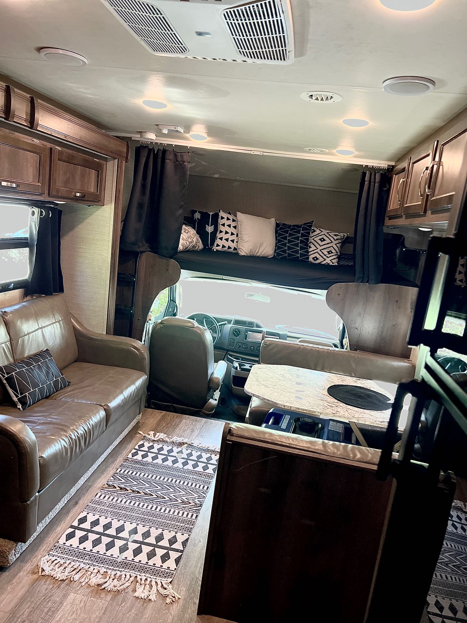 Interior of a spacious rv rental showcasing a comfortable living area with sofa, front bunk, and dining space.. Jayco Redhawk 2018
