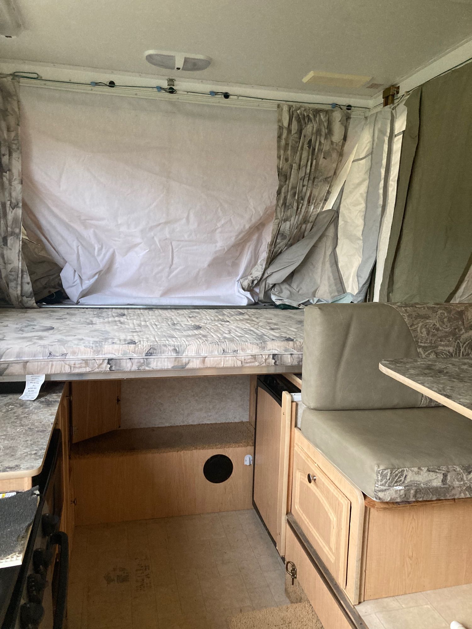 RV rental interior: This pop-up camper offers a fold-out bed, dinette, and kitchen, ideal for compact travel.. Starcraft Starcraft Popup Trailer 2004