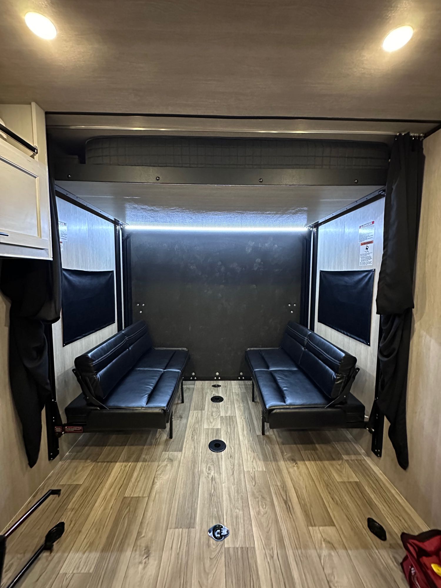 RV rental toy hauler interior. Features dual convertible sofas, overhead bunk, and durable floor with tie-downs for gear.. Genesis Supreme Rv Vortex Limited XL VFS275XL 2024