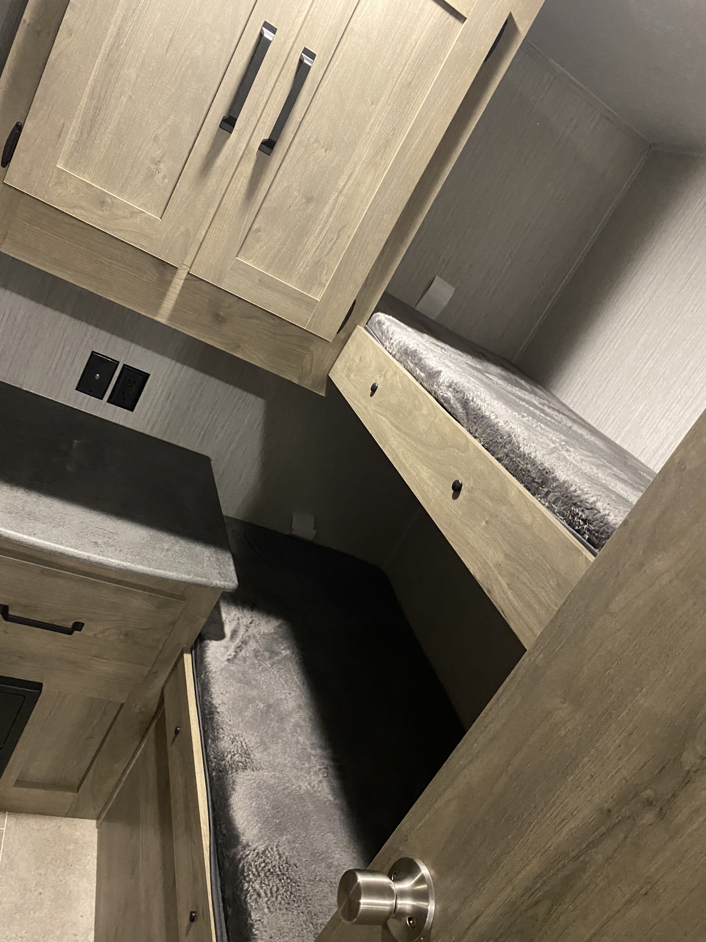 Explore this RV rental's cozy bunk beds, light wood cabinets, and functional counter space, ideal for trips.. Forest River Palomino Puma XLE Lite 2021