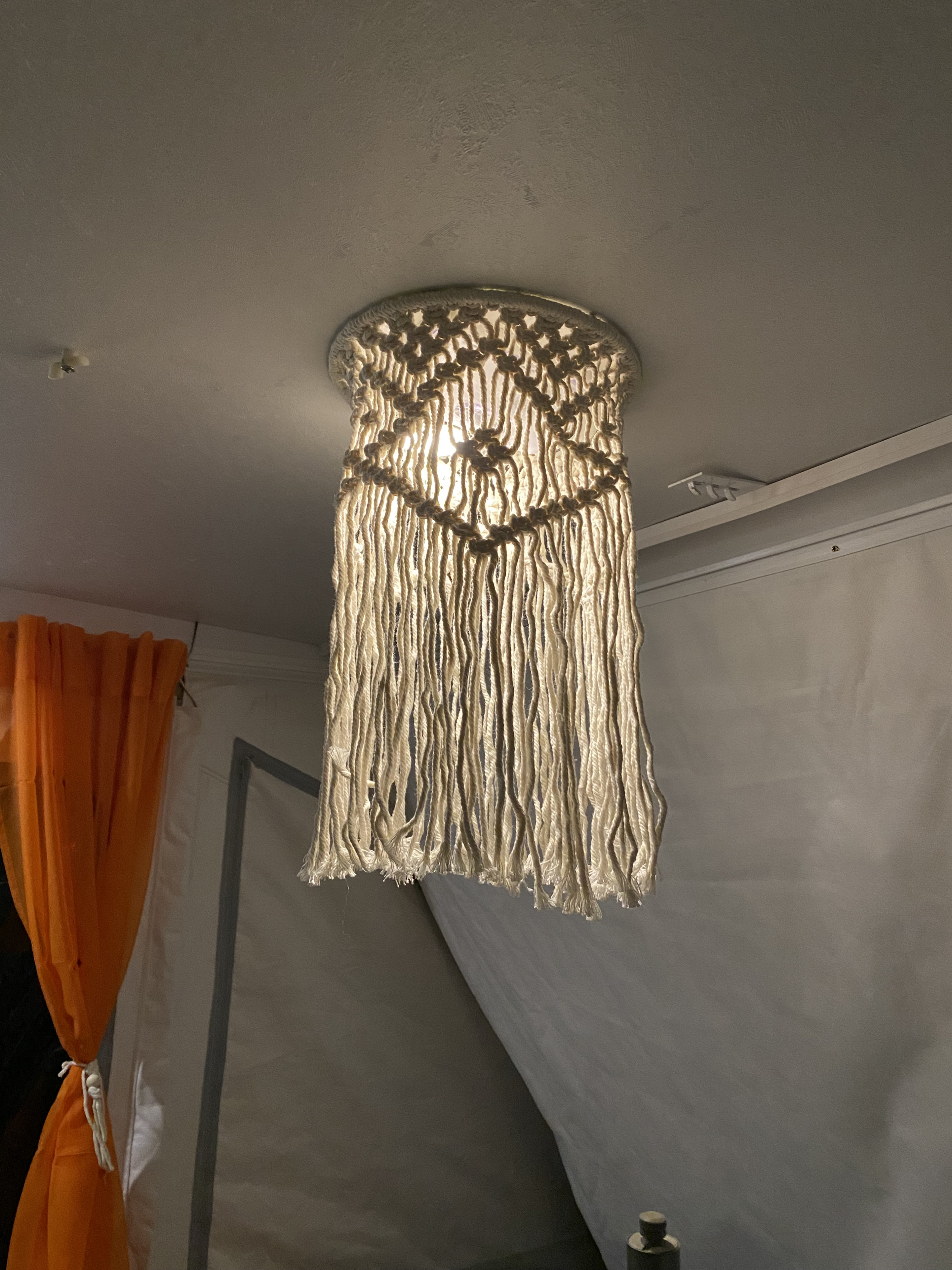 Cozy RV rental interior with a bright macrame pendant light. Orange curtains and simple decor enhance the space.. Viking Recreational Vehicles, INC. Model 548 2000