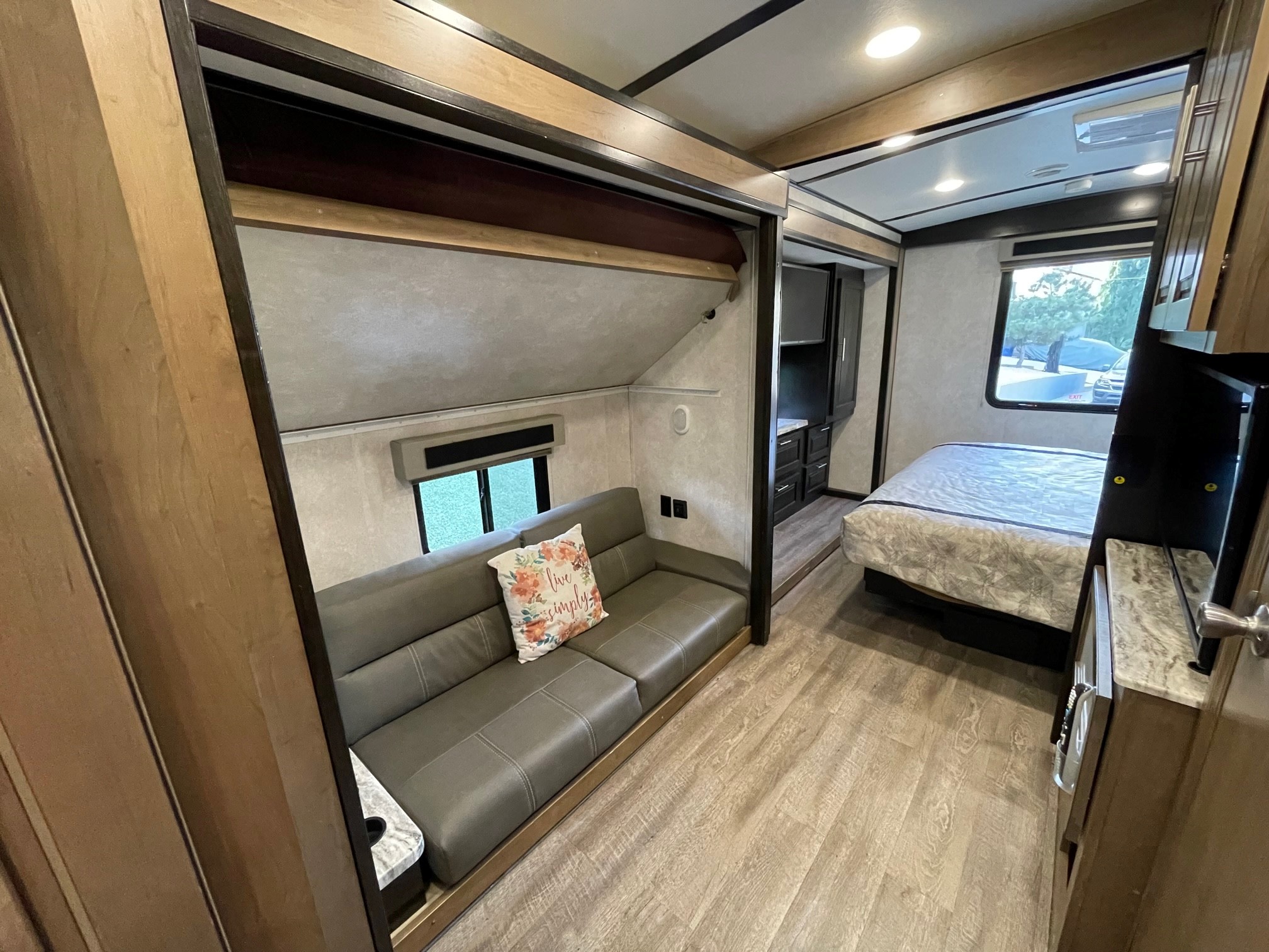 Spacious RV rental interior: a grey sofa in the living area smoothly transitions into the bedroom with a bed. Wood-look flooring throughout.. FR3 FR3 Motorhome 2019