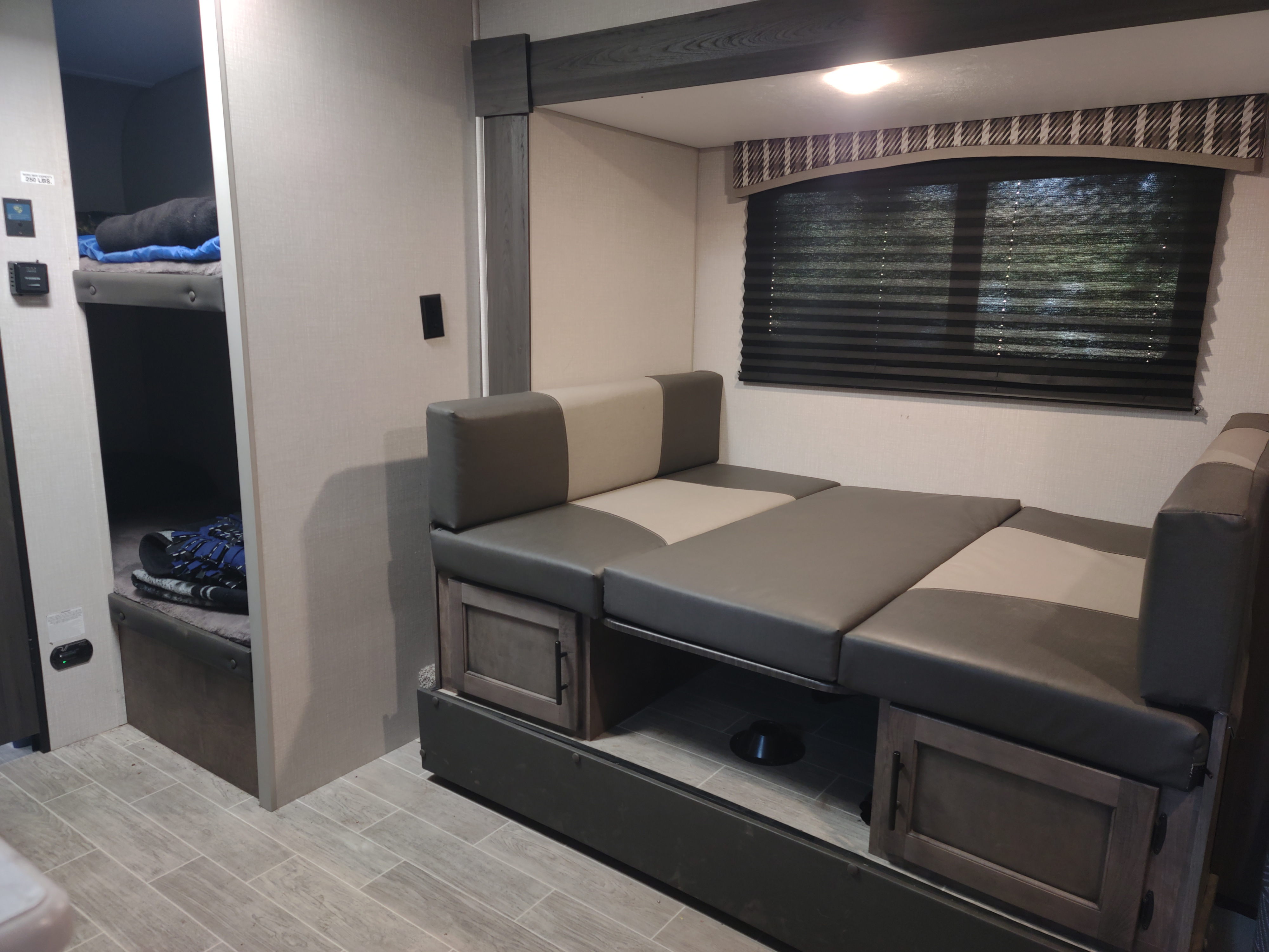 Inside an RV rental, discover bunk beds and a versatile dinette that transforms into a sleeping area, maximizing space for your adventures.. Sonic Lite 2021