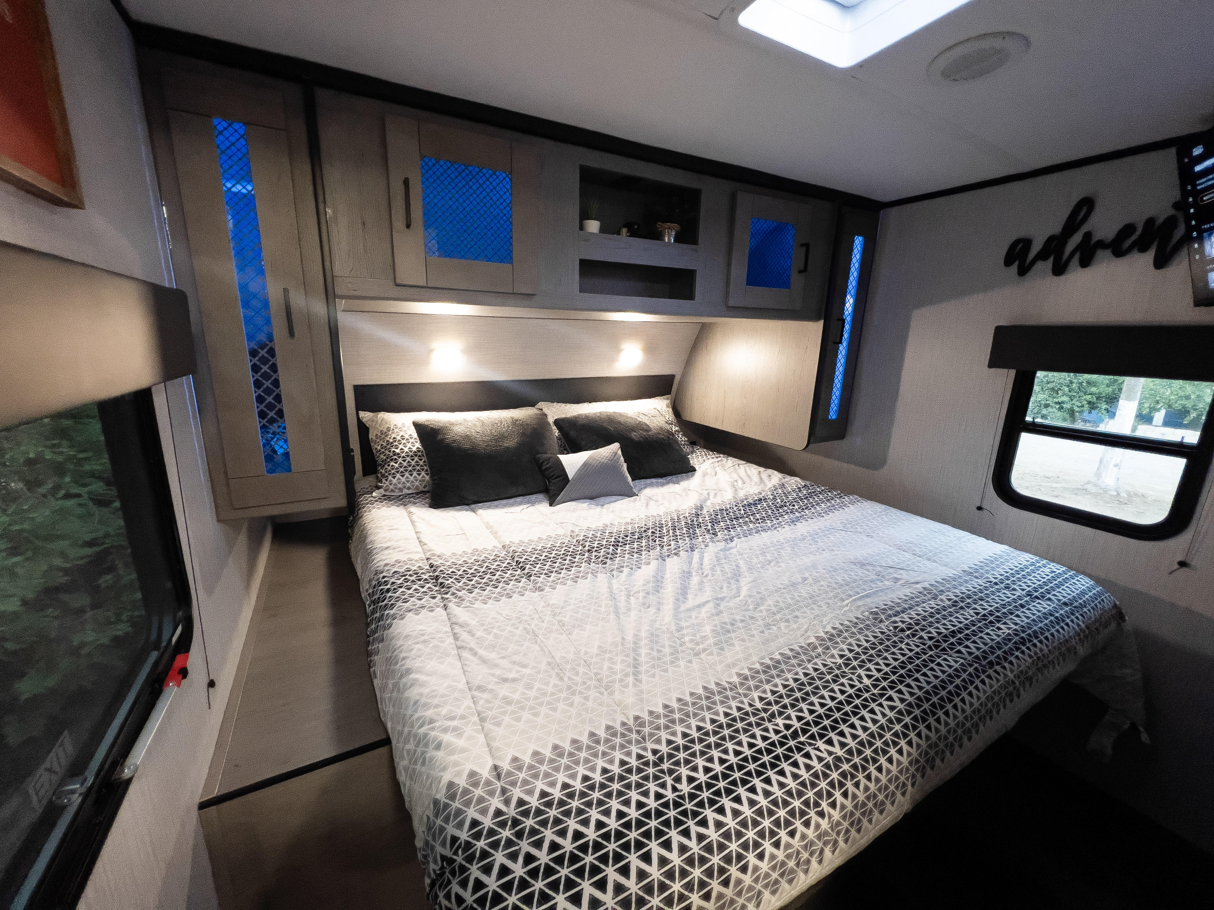 Spacious RV rental bedroom featuring a modern bed, overhead storage, and stylish blue accent lighting.. Heartland RVs Mallard 2021