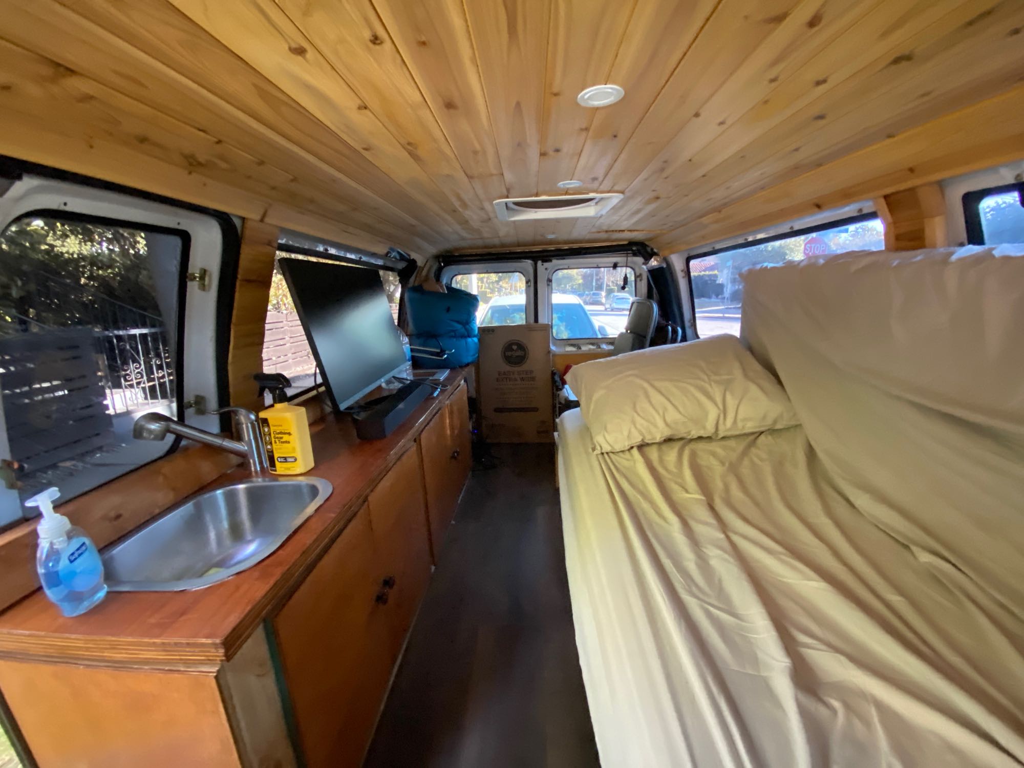 Experience van life in this rv rental camper van. Features include a wooden ceiling, built-in sink, monitor, and bed.. Ford Econoline 150 2003