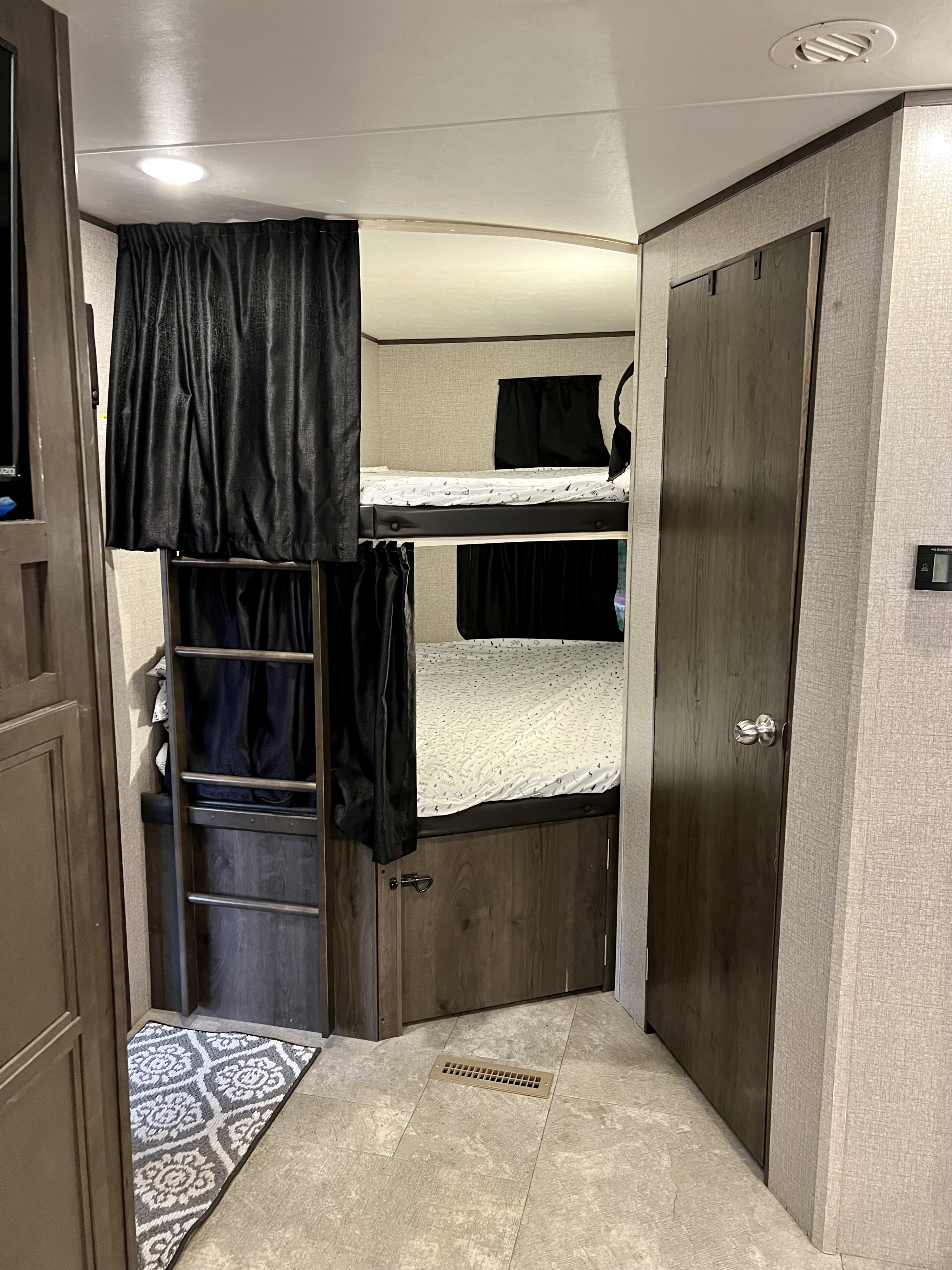 Cozy RV rental bunk beds with privacy curtains and ladder, perfect for families and convenient sleeping.. Jayco Jay Flight 2020