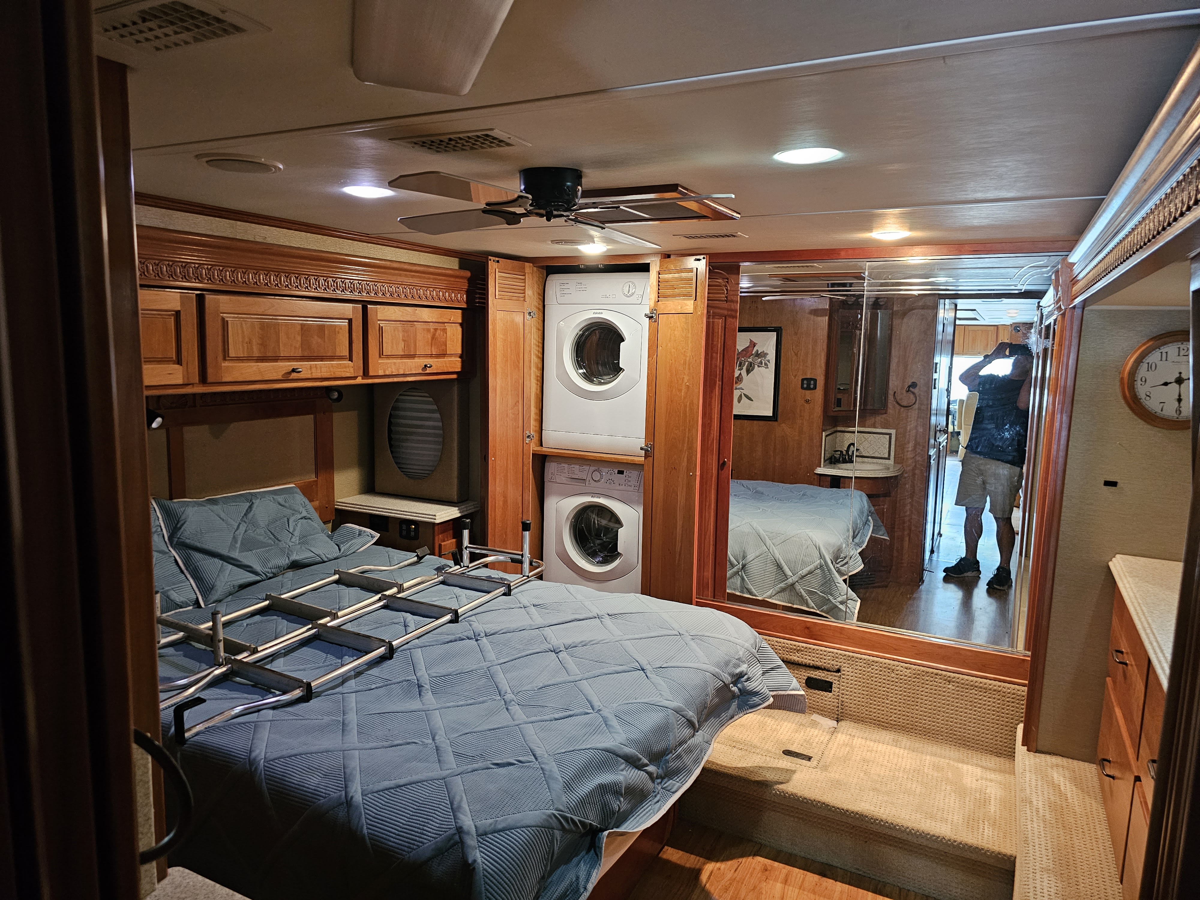 RV rental: Compact bedroom featuring a blue bed with a folding ladder, stacked washer/dryer, ceiling fan, and mirrored wall.. Monaco Dynasty 2008