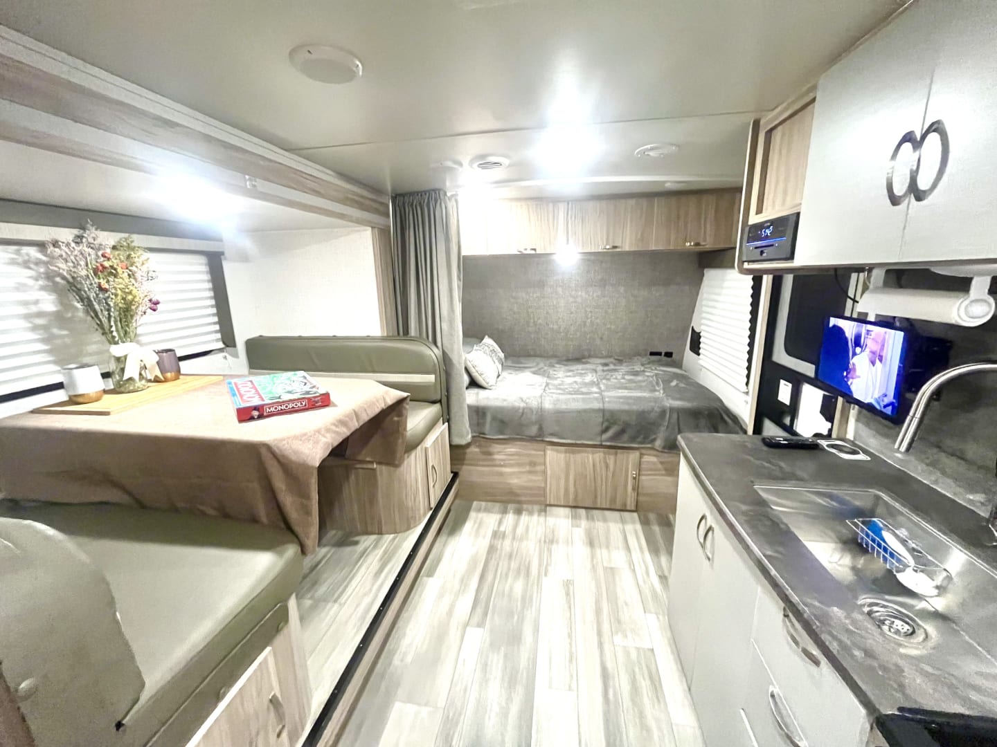 Cozy rv rental interior featuring dining booth, bed, and compact kitchen. Ideal for travel adventures!. Winnebago Minnie Winnie 2022