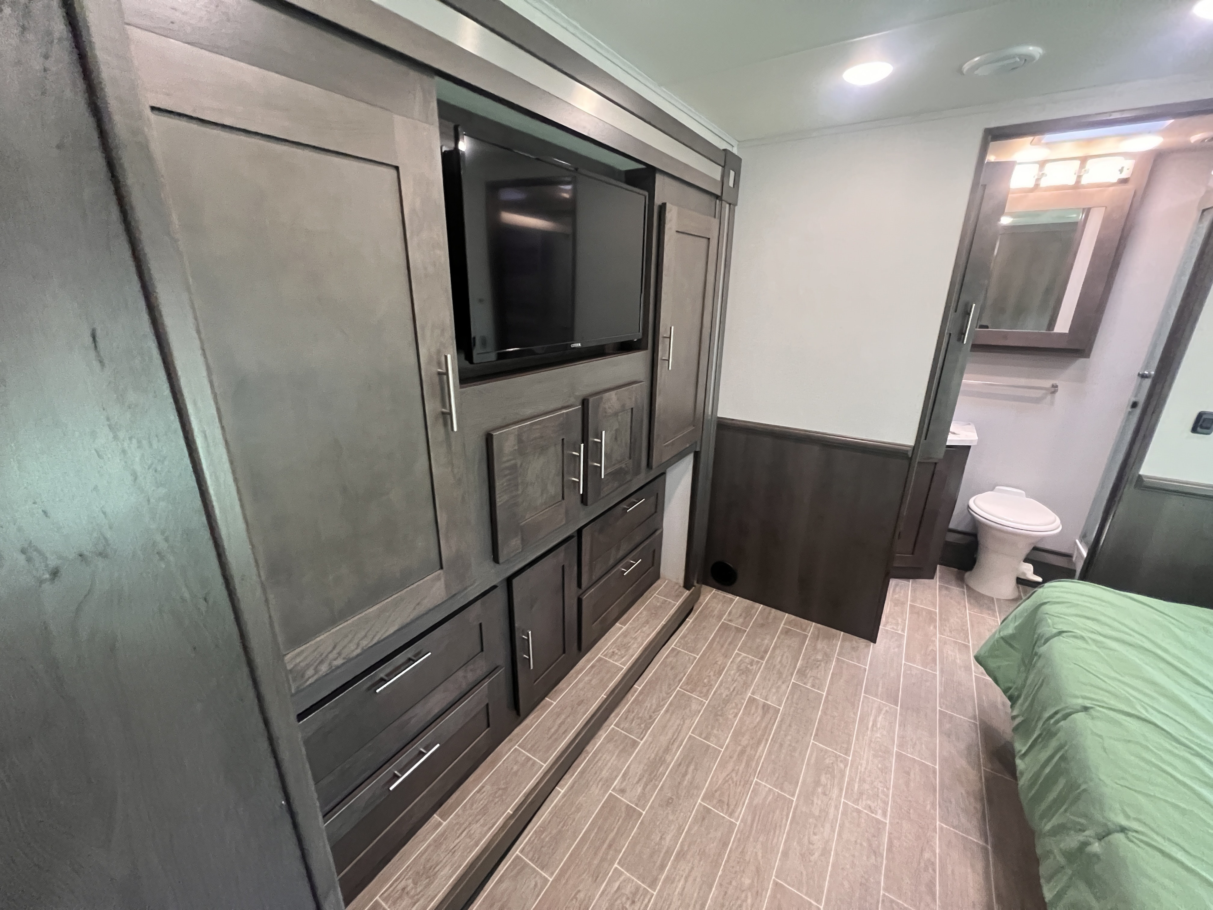 RV rental: Bedroom interior featuring dark cabinetry with a TV, drawers, and an accessible en-suite toilet.. Forest River Georgetown 2022