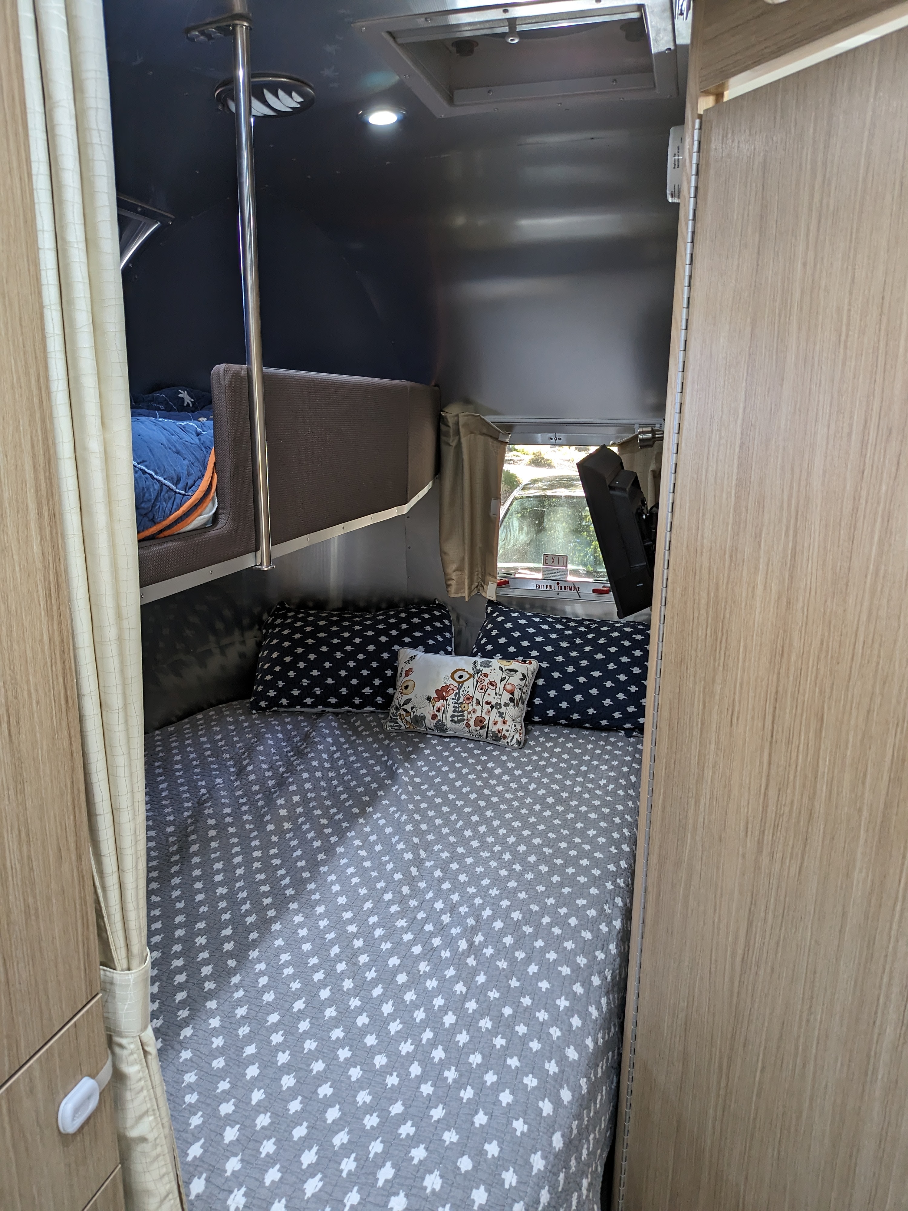 Cozy RV rental sleeping area featuring a main bed, bunk bed, and modern interior. Perfect for family adventures.. Airstream Flying Cloud 2020
