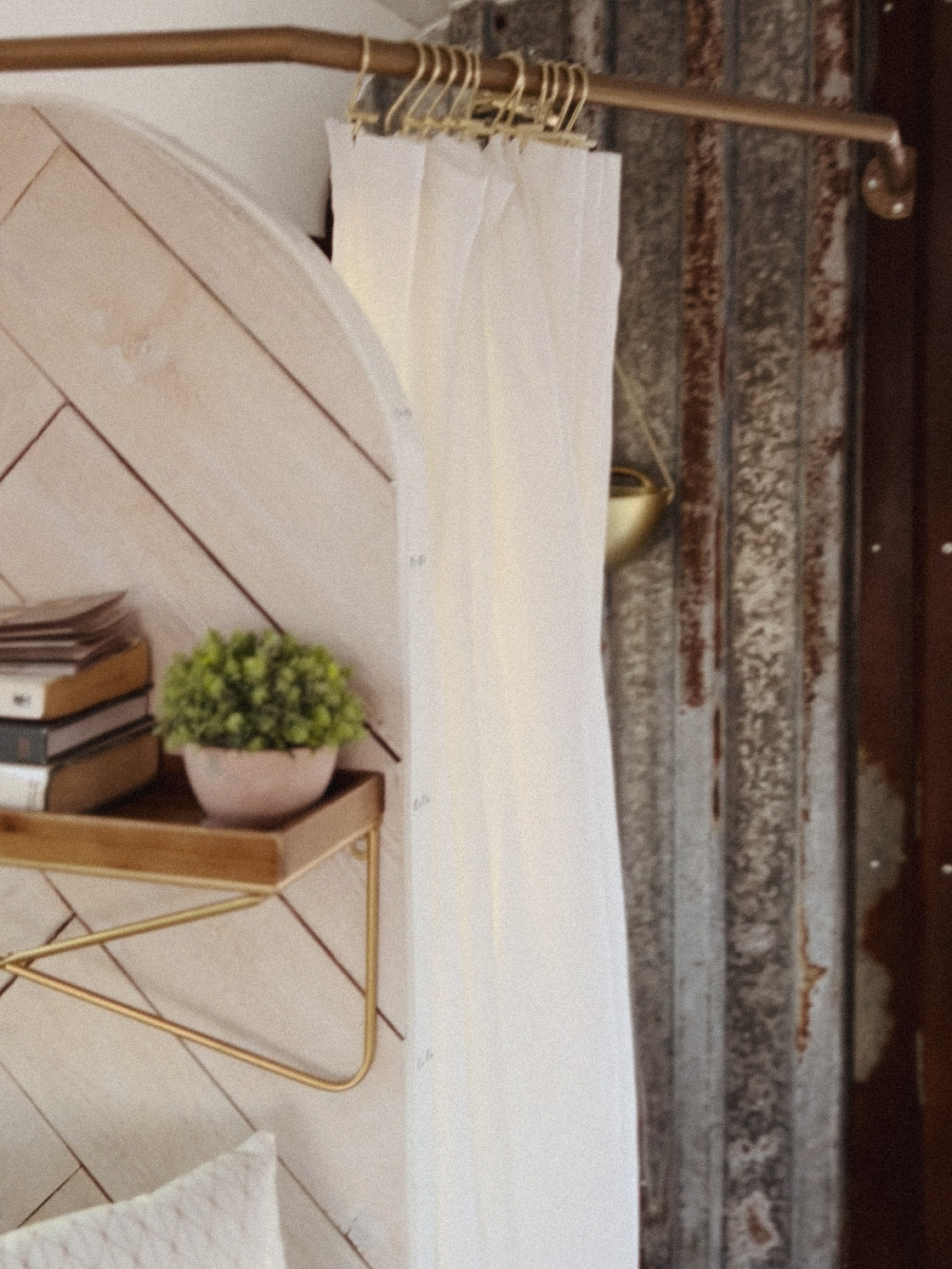 Cozy RV rental interior featuring stylish white curtains on a gold rod, a rustic metal wall, and a shelf with a plant.. Ford E450 1999