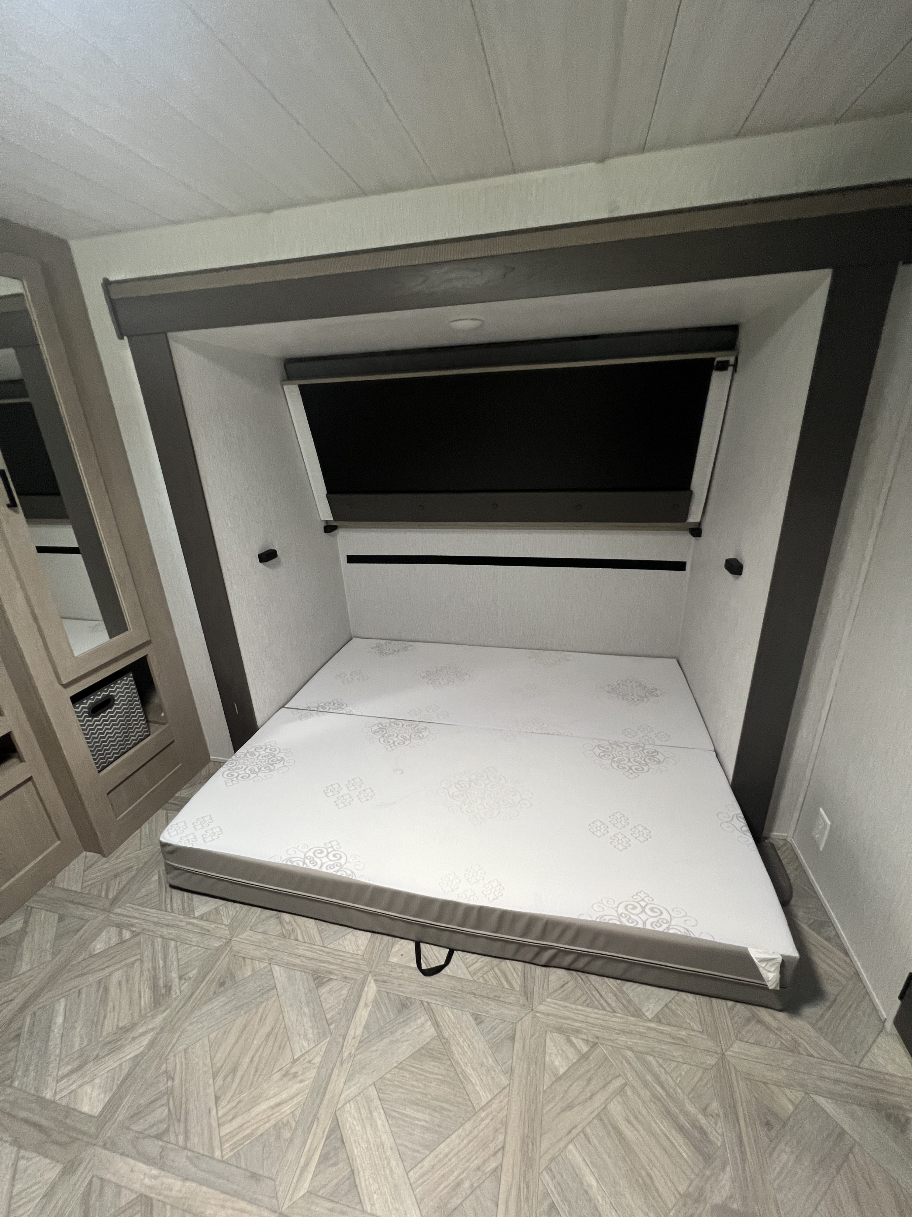 RV rental bedroom featuring a two-piece mattress and modern patterned flooring, ready for use.. Forest River 31KQBTS 2024