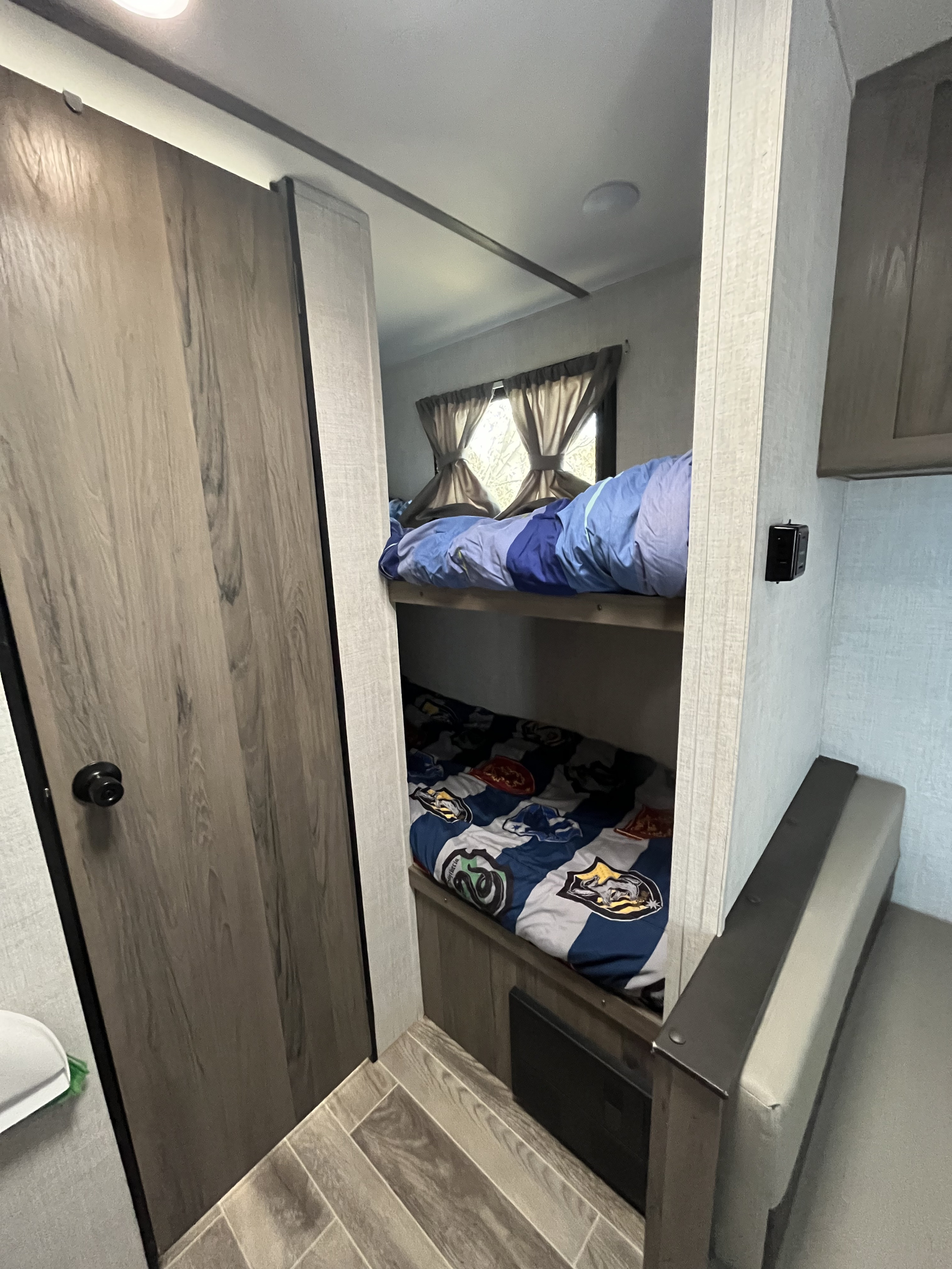 Cozy RV rental interior featuring practical bunk beds and a compact living area, perfect for family trips.. Gulf Stream Ameri-Lite Super Lite 2022